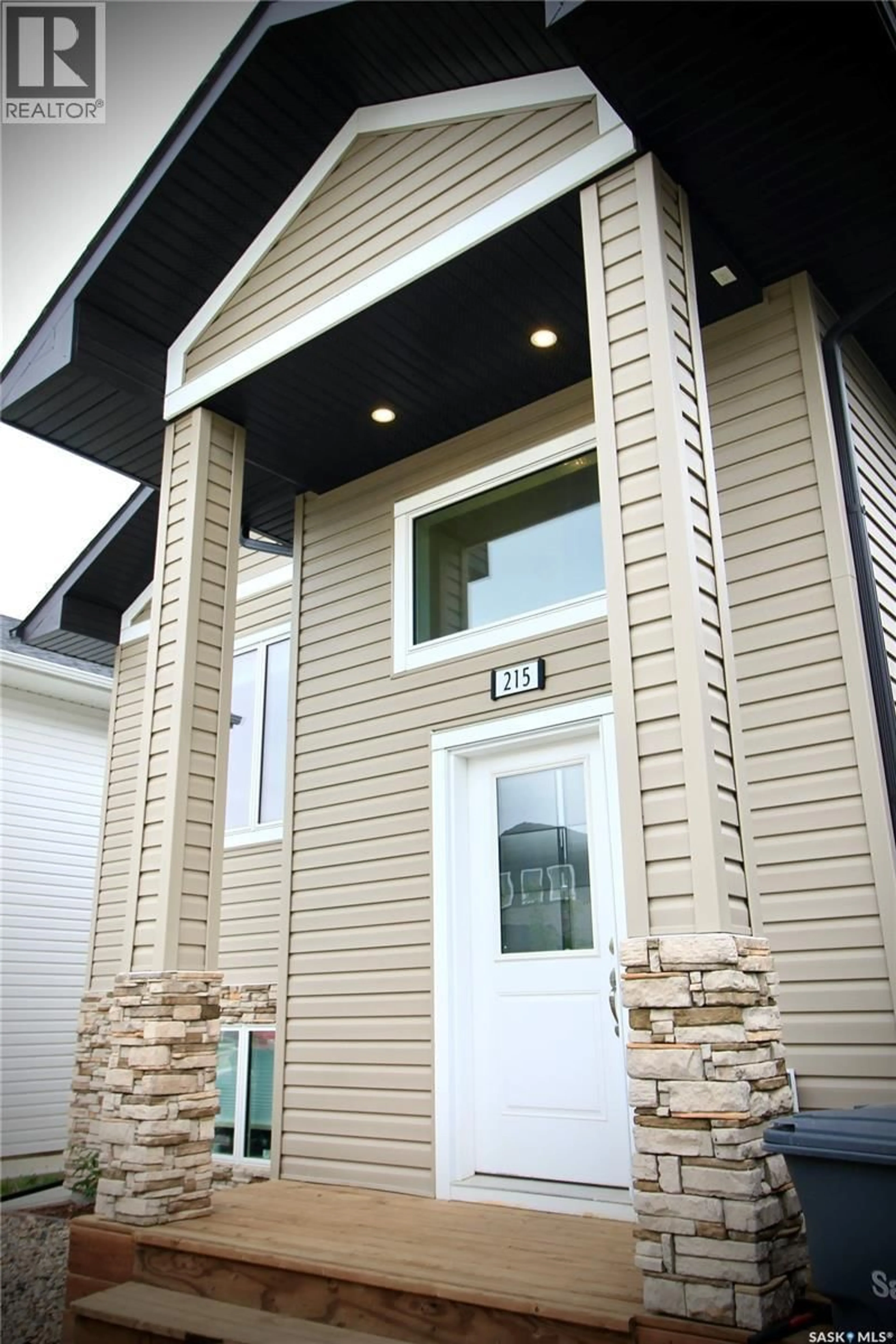 Home with vinyl exterior material, street for 215 THAKUR STREET, Saskatoon Saskatchewan S7W1C4