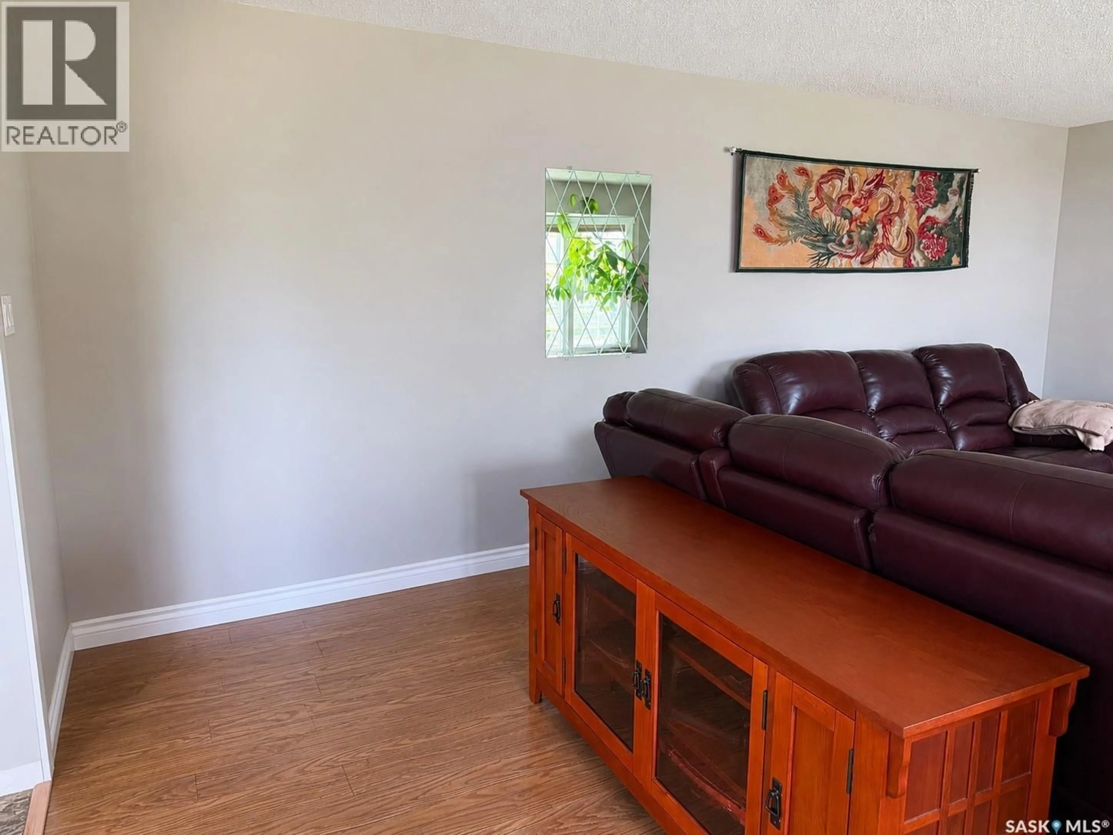 Living room with furniture, wood/laminate floor for 23 TUFTS CRESCENT, Outlook Saskatchewan S0L2N0