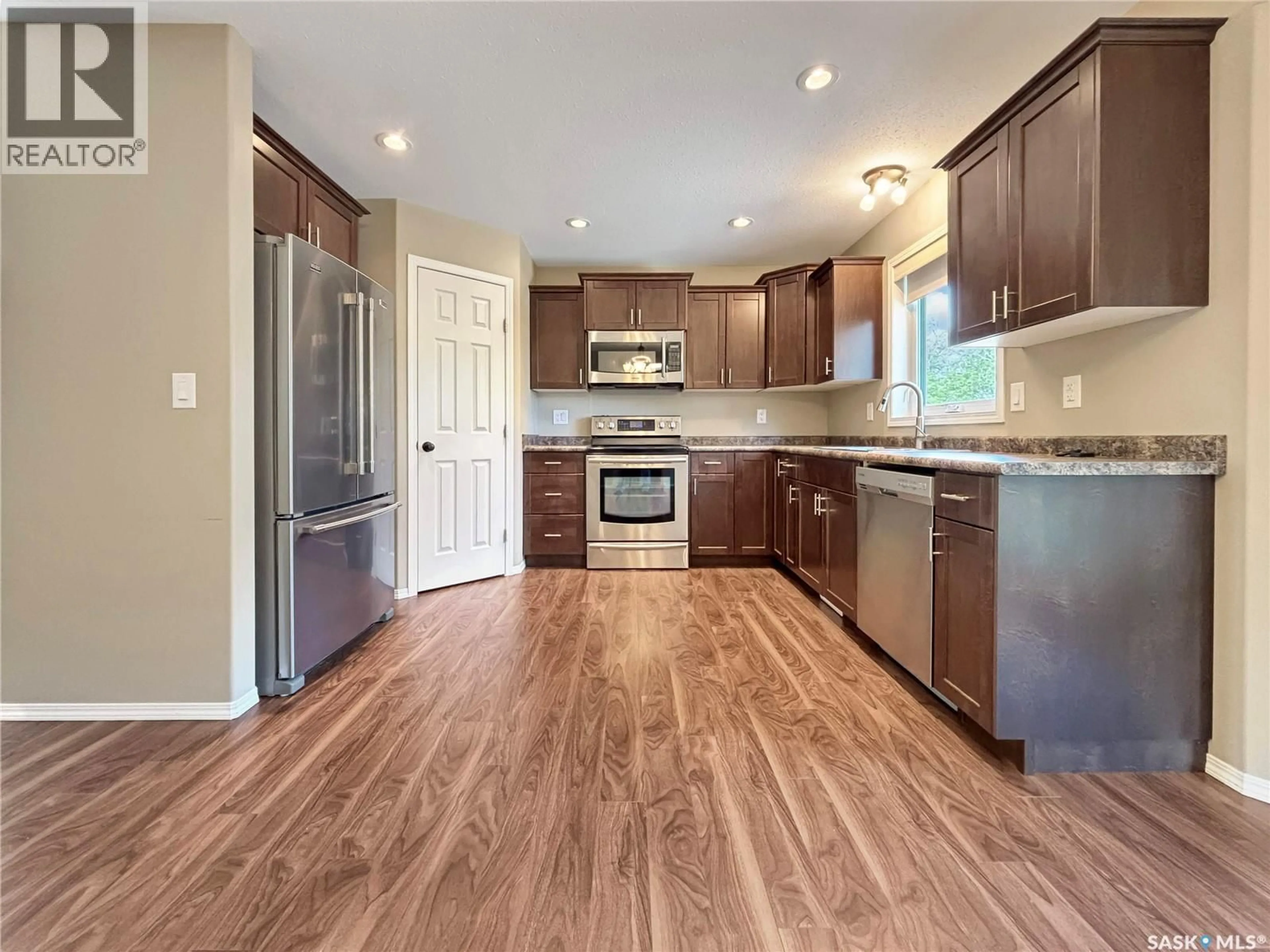 Open concept kitchen, wood/laminate floor for 303 DIEFENBAKER AVENUE, Hague Saskatchewan S0K1X0