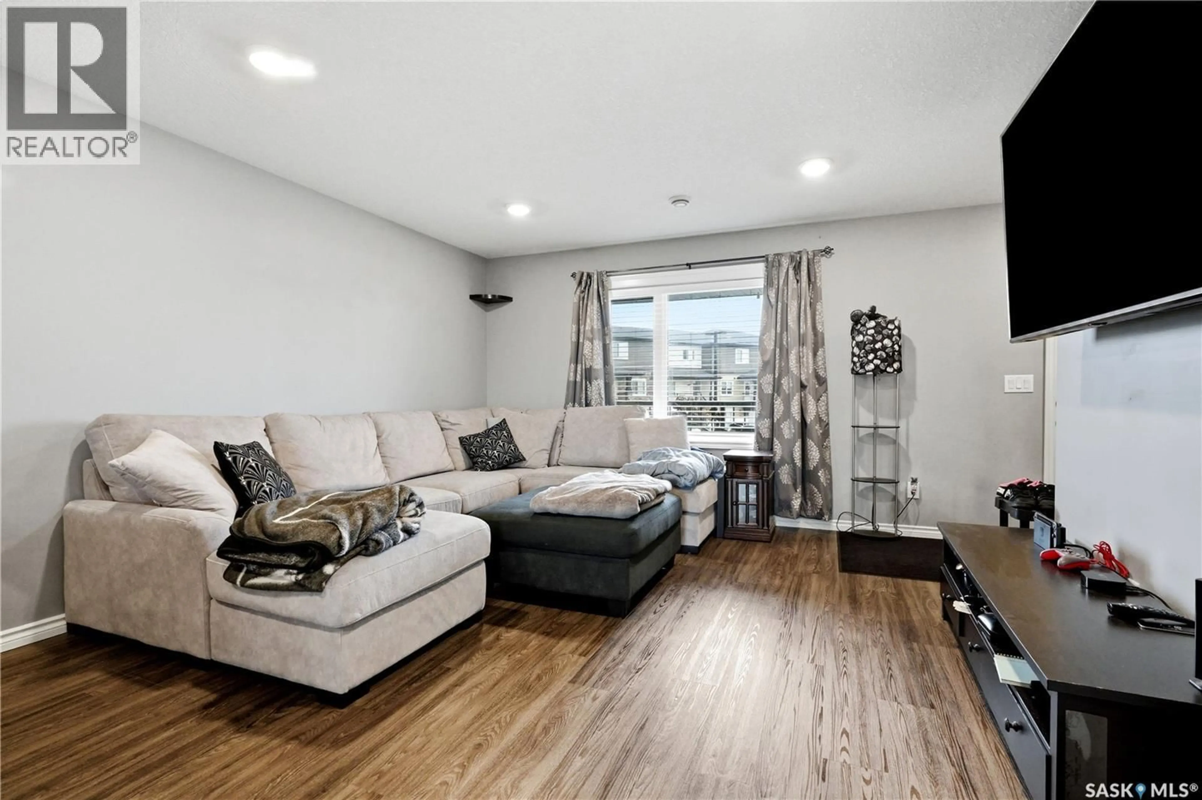 Living room with furniture, wood/laminate floor for 110 - 618 AKHTAR BEND, Saskatoon Saskatchewan S7W0B8