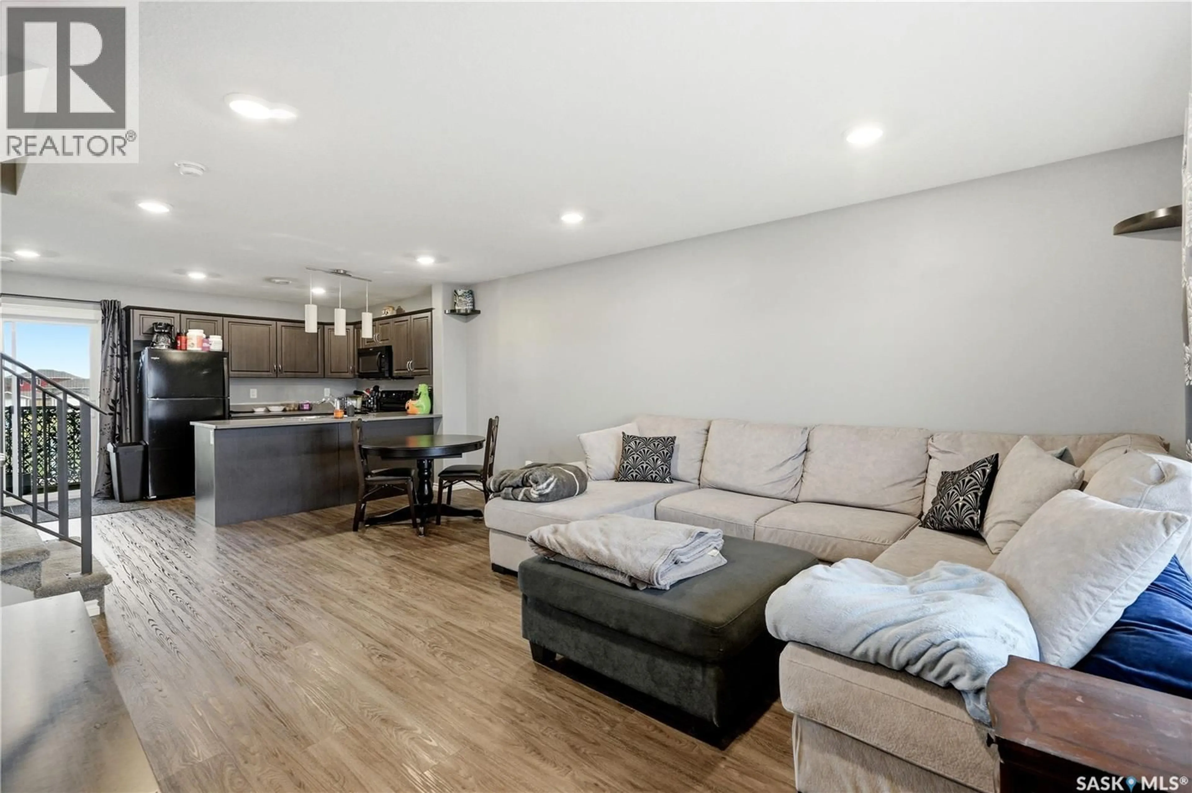 Living room with furniture, wood/laminate floor for 110 - 618 AKHTAR BEND, Saskatoon Saskatchewan S7W0B8