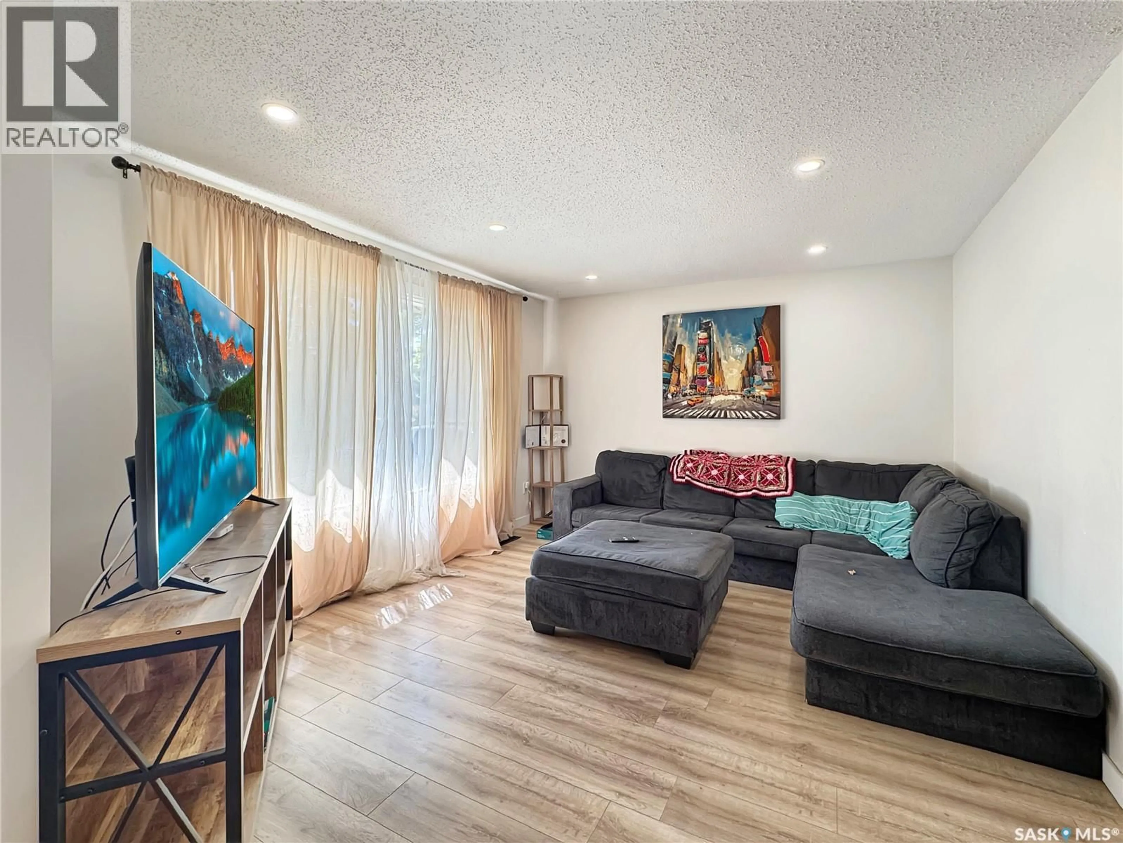 Living room with furniture, wood/laminate floor for 1321 108TH STREET, North Battleford Saskatchewan S9A2B6