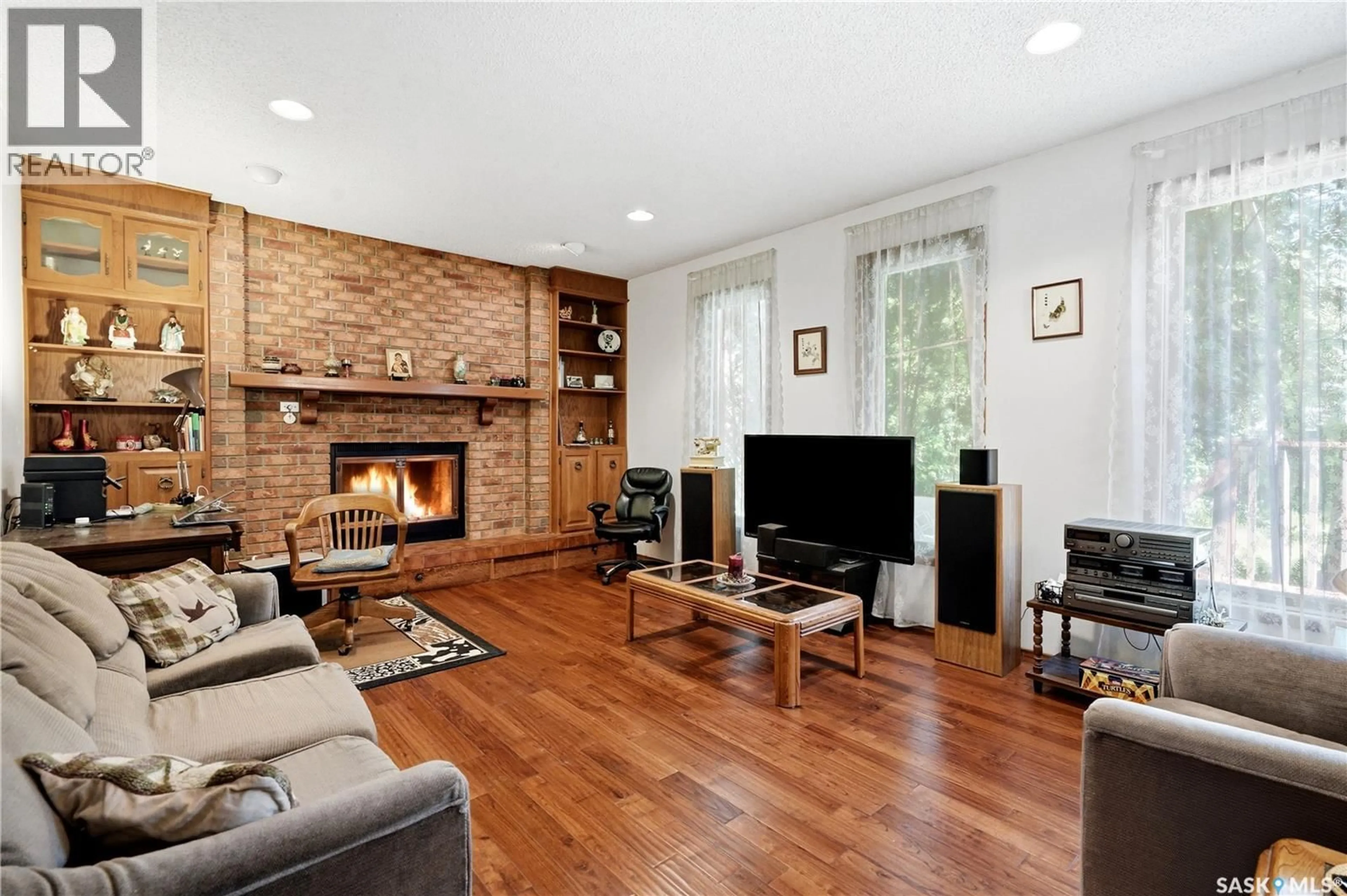 Living room with furniture, wood/laminate floor for 211 KEELEY CRESCENT, Saskatoon Saskatchewan S7J4B9