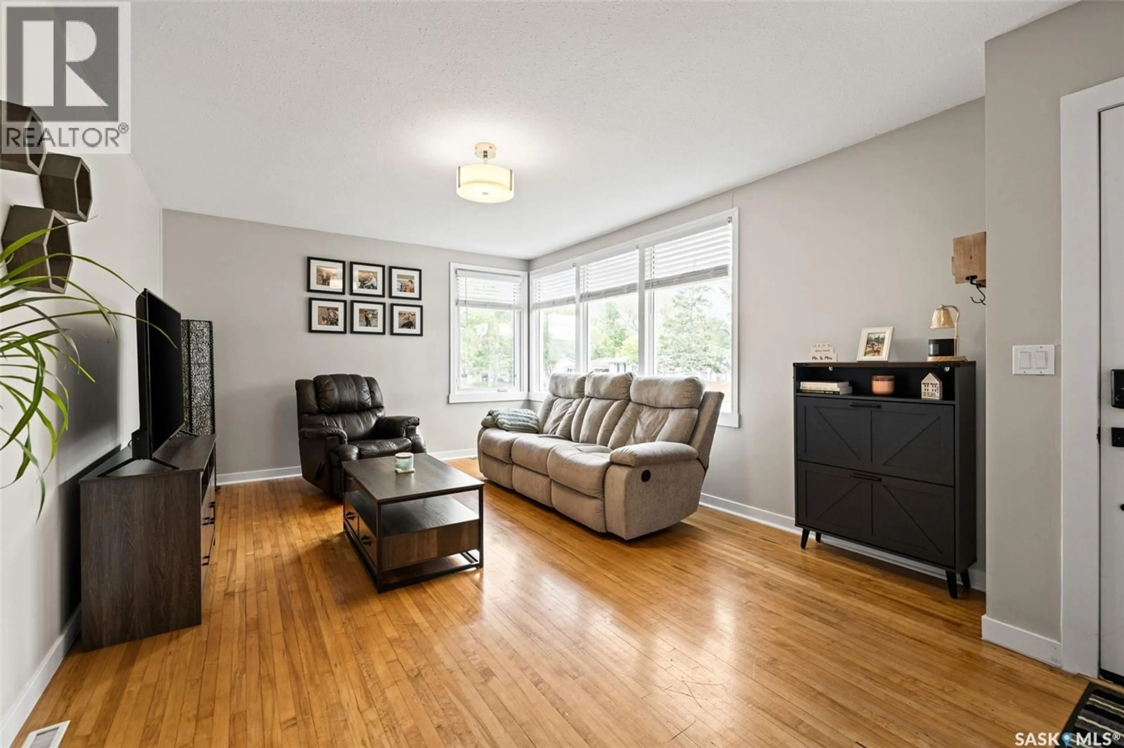 Living room with furniture, wood/laminate floor for 4835 7TH AVENUE, Regina Saskatchewan S4T0R8