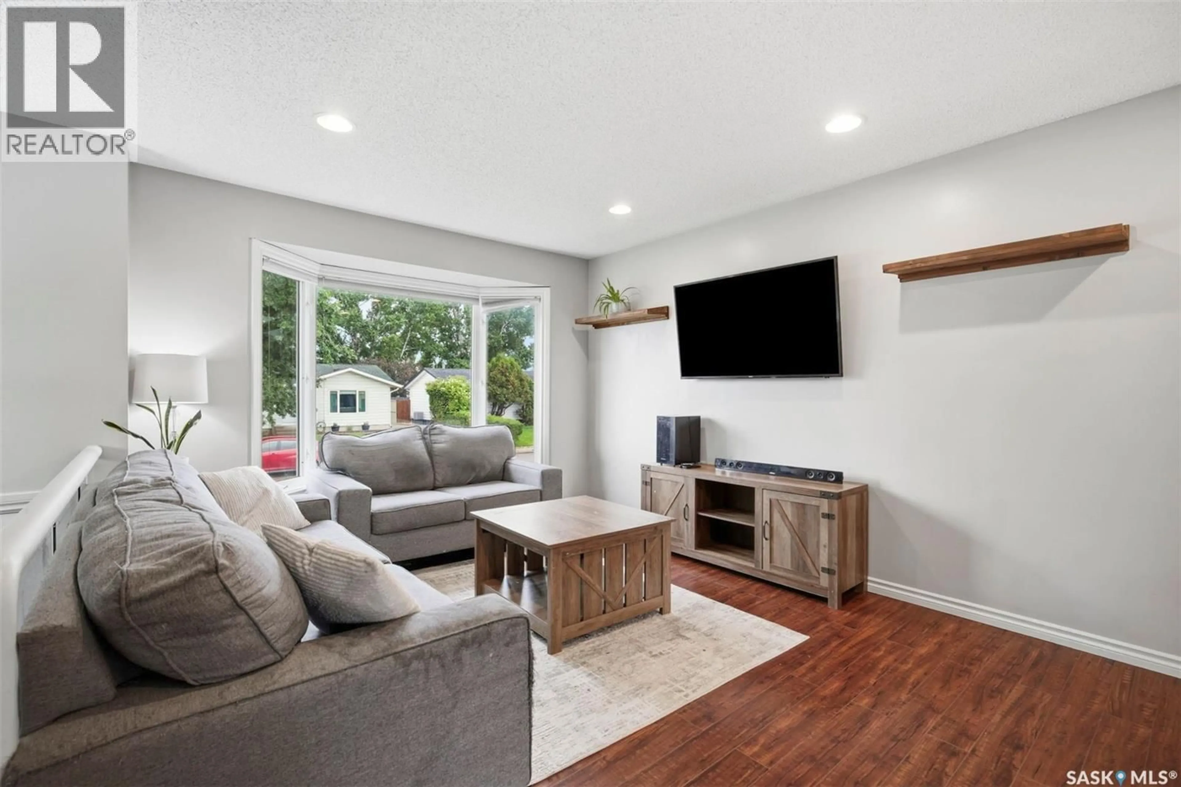 Living room with furniture, wood/laminate floor for 423 NESBITT WAY, Saskatoon Saskatchewan S7L6S3
