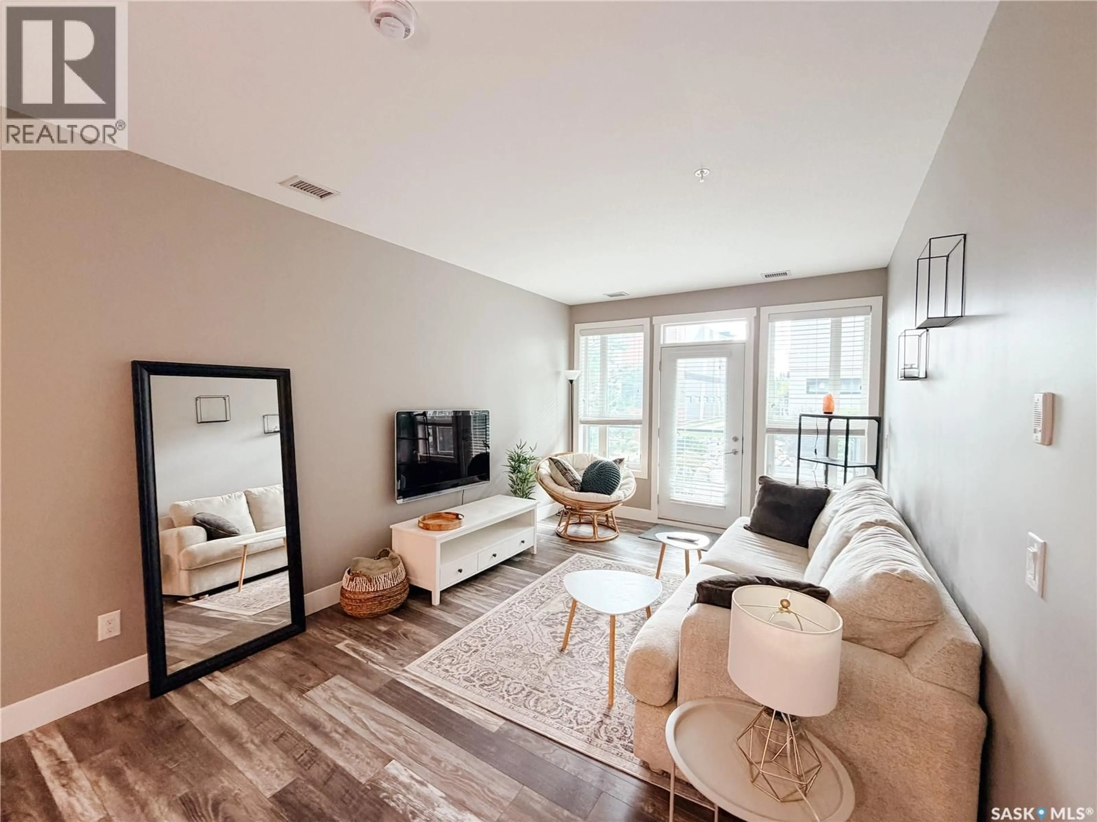 Living room with furniture, wood/laminate floor for 415 - 115 MANINGAS BEND, Saskatoon Saskatchewan S7W0T6