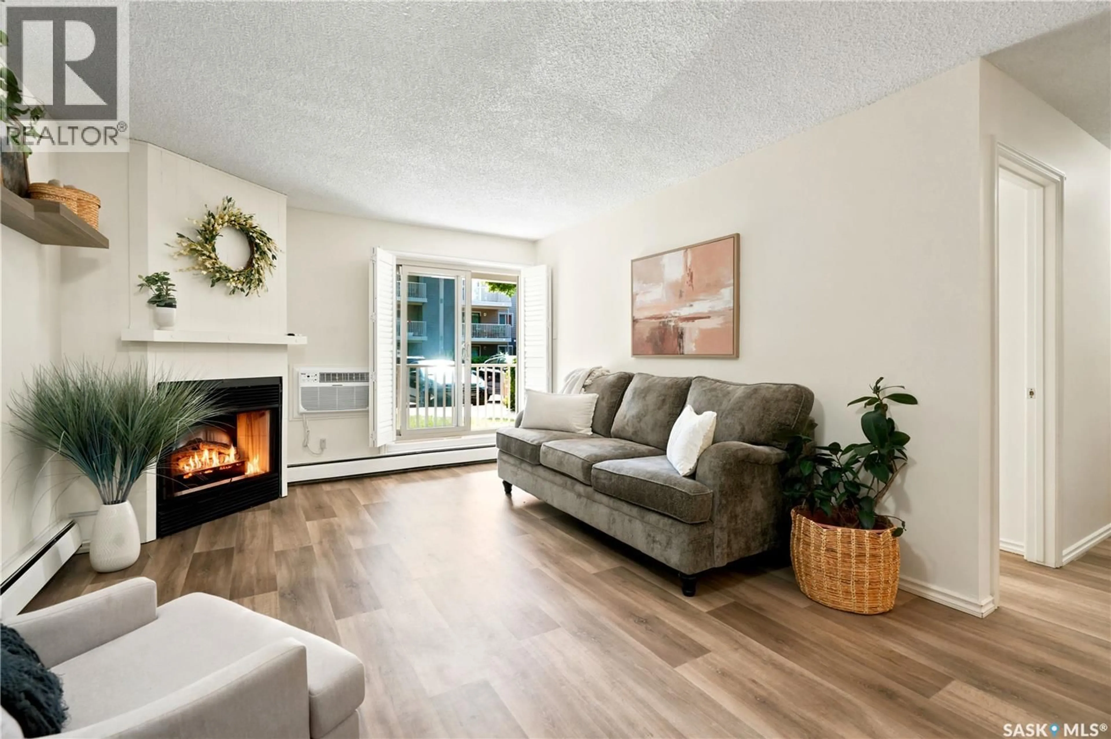 Living room with furniture, wood/laminate floor for 103A2 - 1121 MCKERCHER DRIVE, Saskatoon Saskatchewan S7H5K9