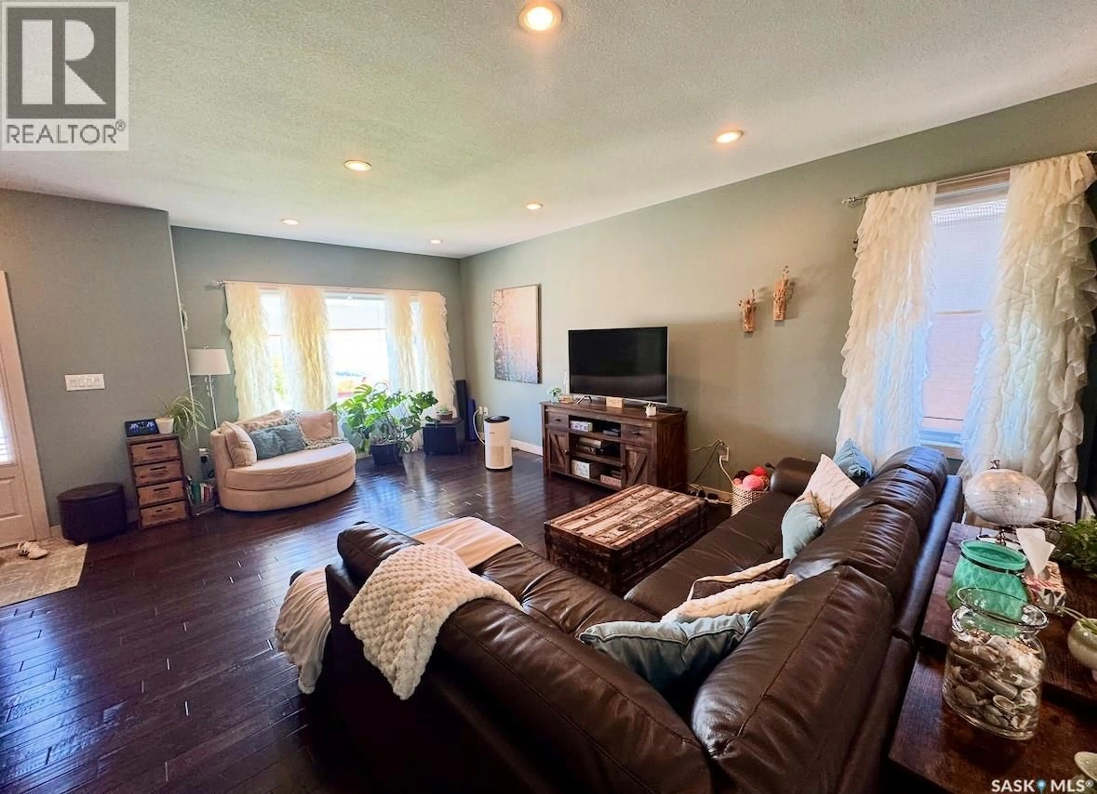 Living room with furniture, wood/laminate floor for 691 BARBER CRESCENT, Weyburn Saskatchewan S4H0B9