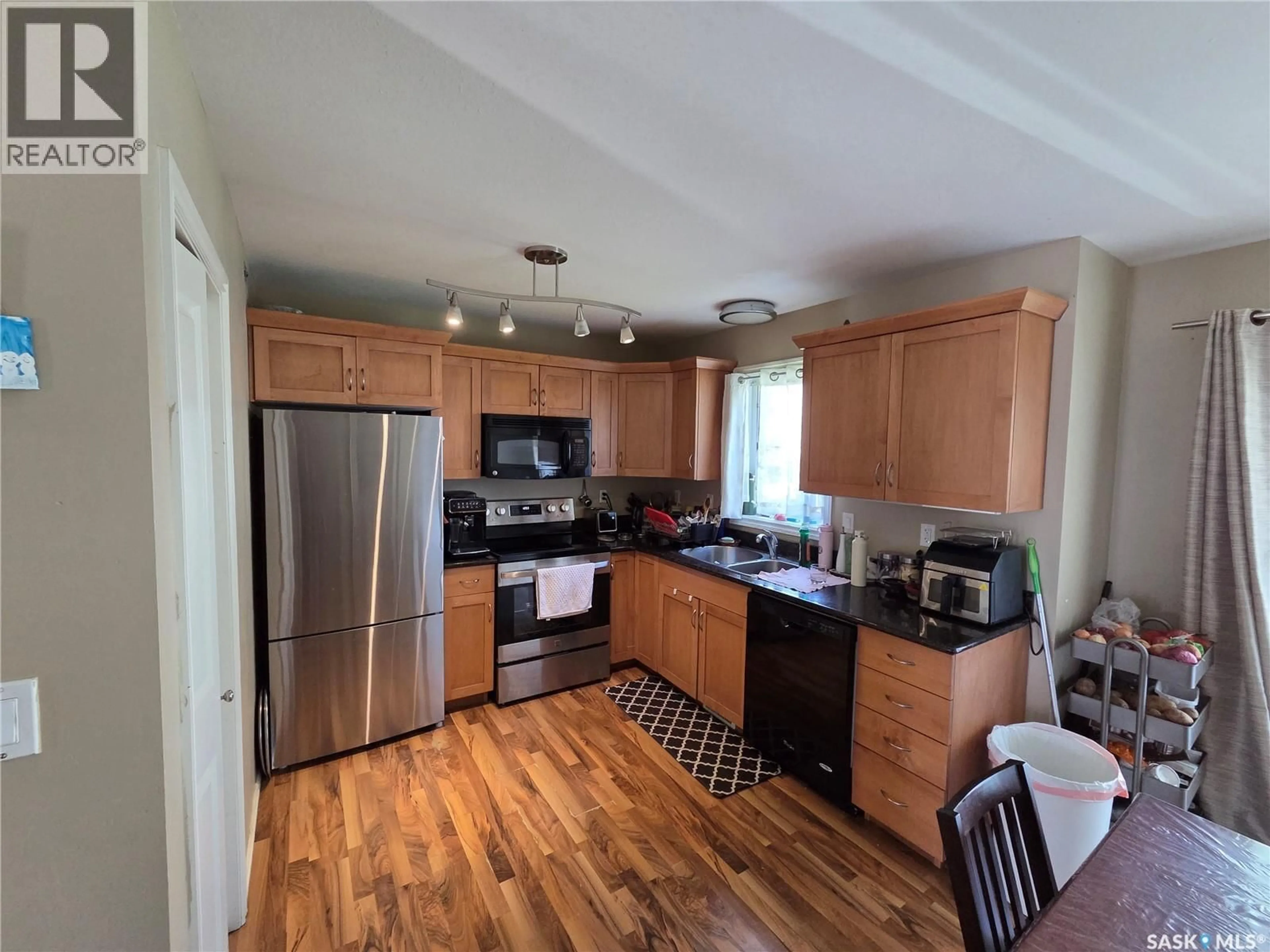 Open concept kitchen, wood/laminate floor for 303 SLIMMON PLACE, Saskatoon Saskatchewan S7V0A8