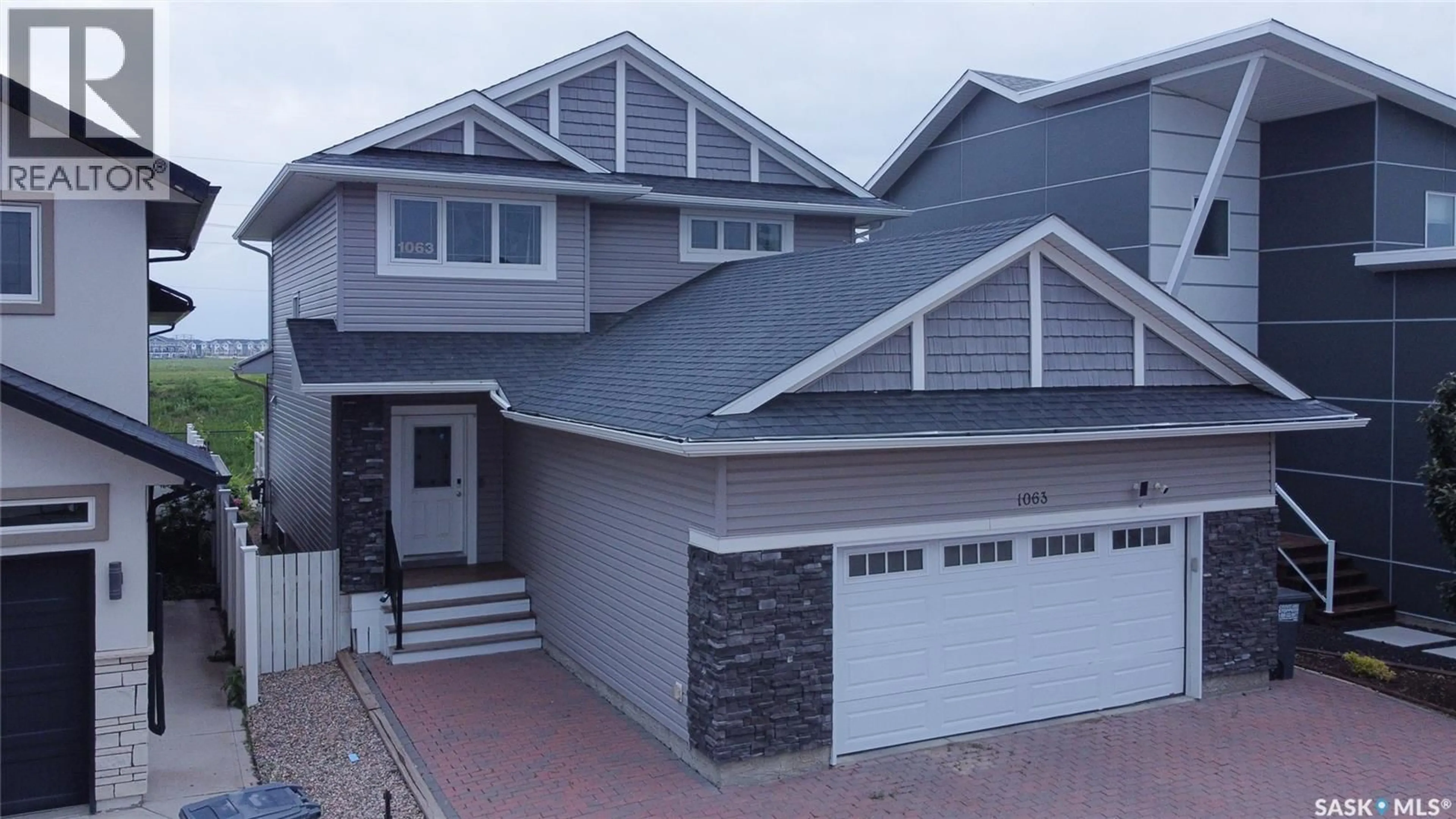 Home with vinyl exterior material, street for 1063 GLACIAL SHORES COMMON, Saskatoon Saskatchewan S7W0R2