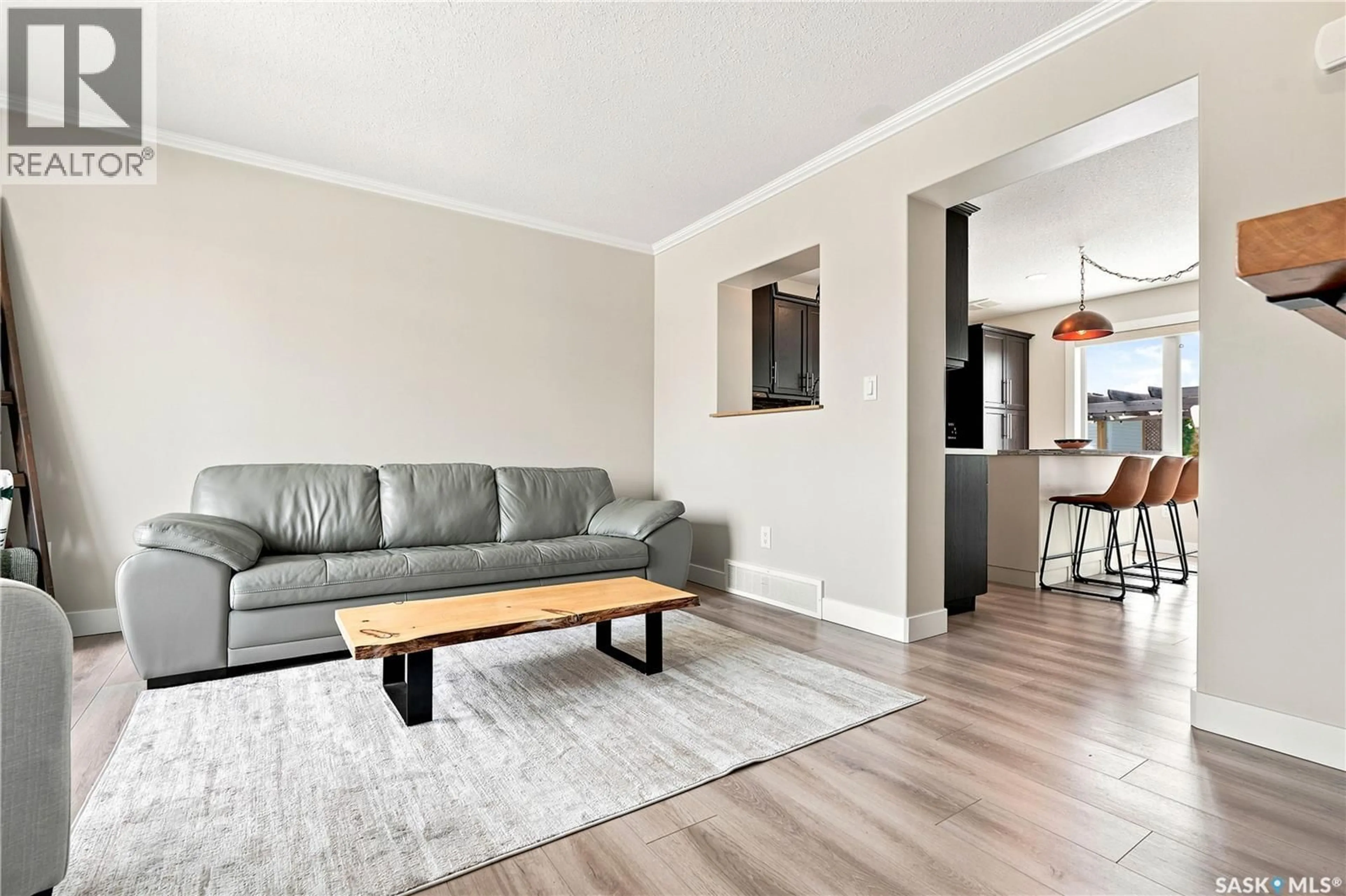 Living room with furniture, wood/laminate floor for 944 GLENVIEW COVE, Martensville Saskatchewan S0K0A2
