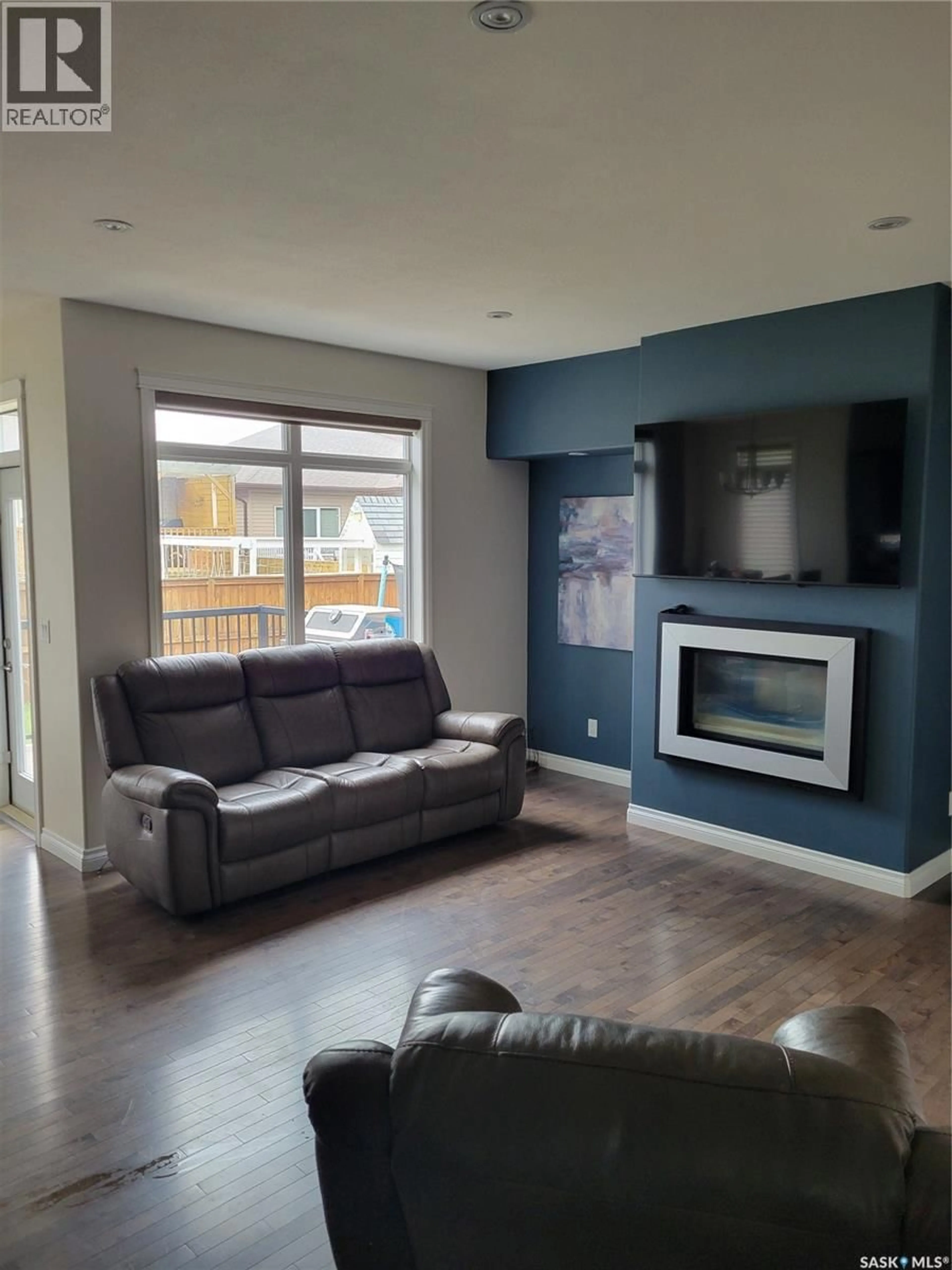 Living room with furniture, wood/laminate floor for 718 PATRICK BAY, Saskatoon Saskatchewan S7W0G3