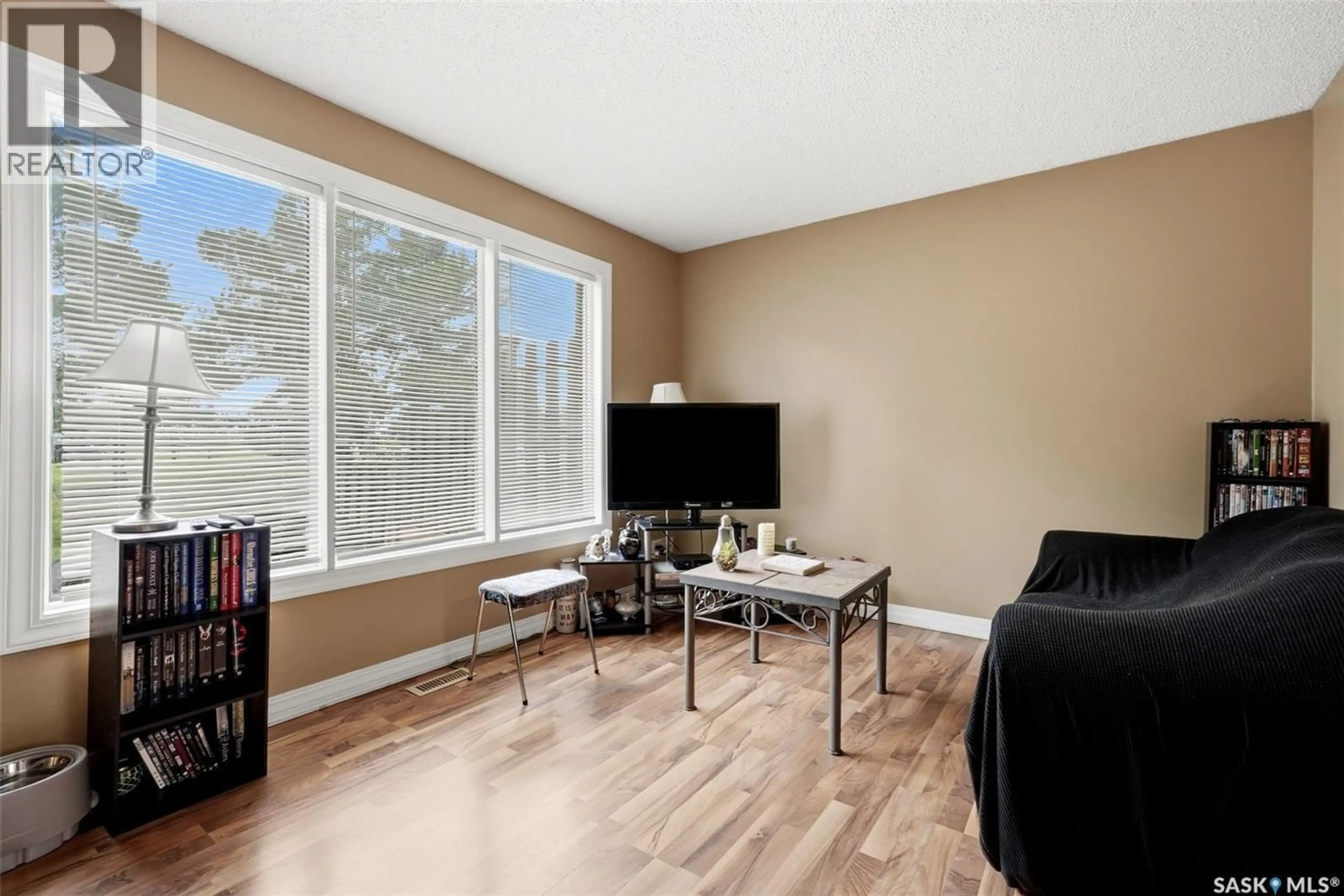 Living room with furniture, wood/laminate floor for 3828 CASTLE ROAD, Regina Saskatchewan S4S6M7