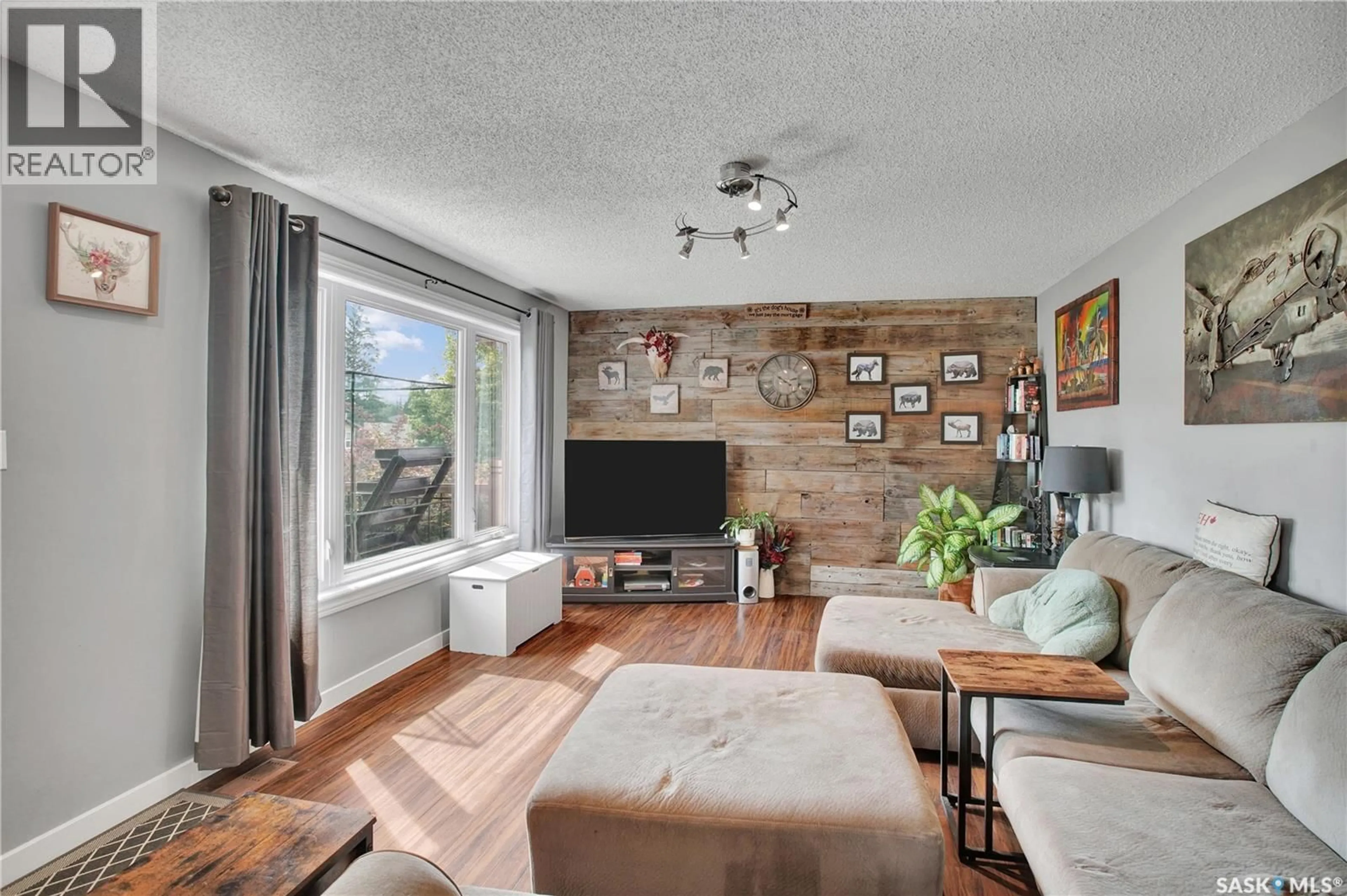 Living room with furniture, wood/laminate floor for 1515 CRERAR DRIVE, Saskatoon Saskatchewan S7M4R8
