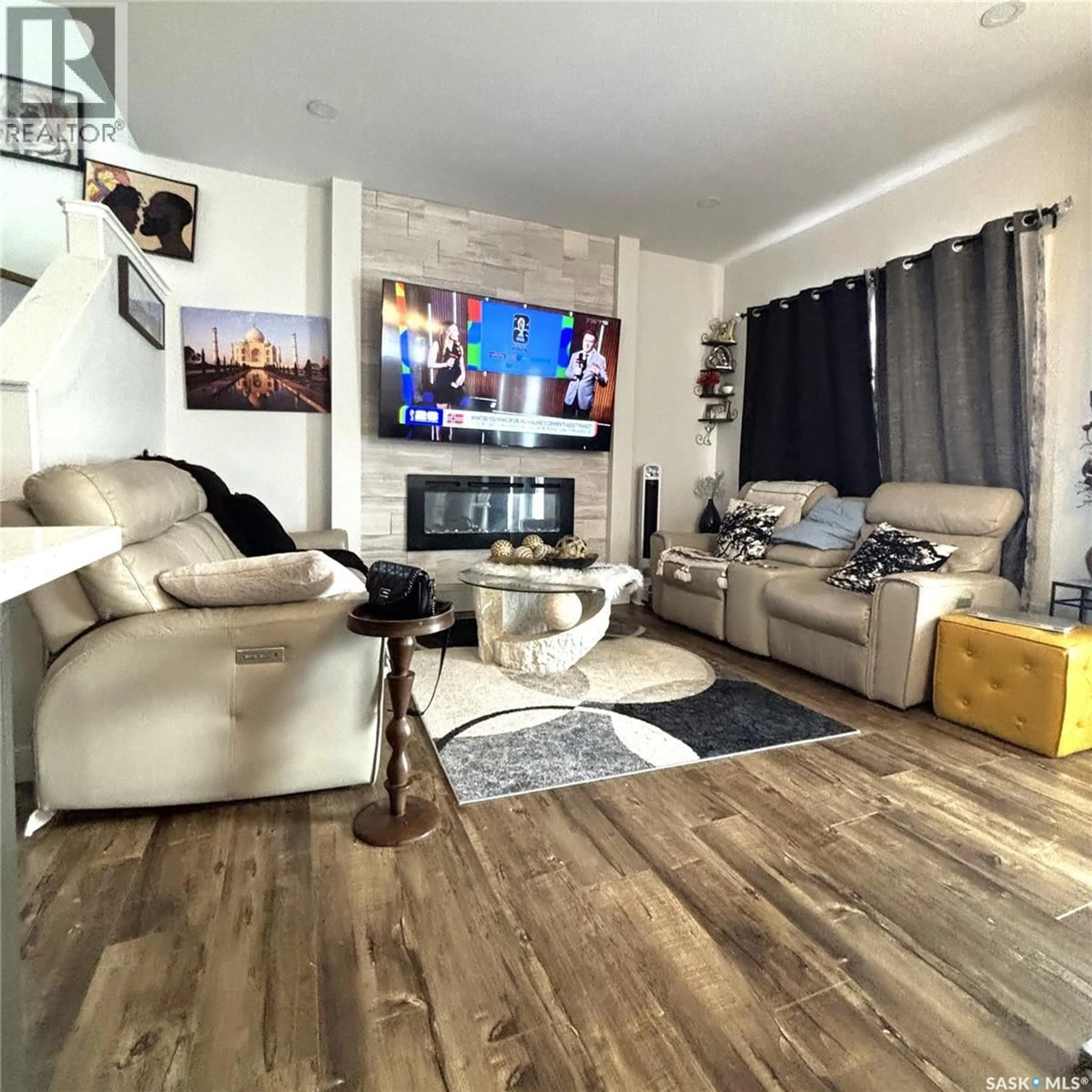 Living room with furniture, wood/laminate floor for 254 ANISKOTAW MANOR, Saskatoon Saskatchewan S7V1L9