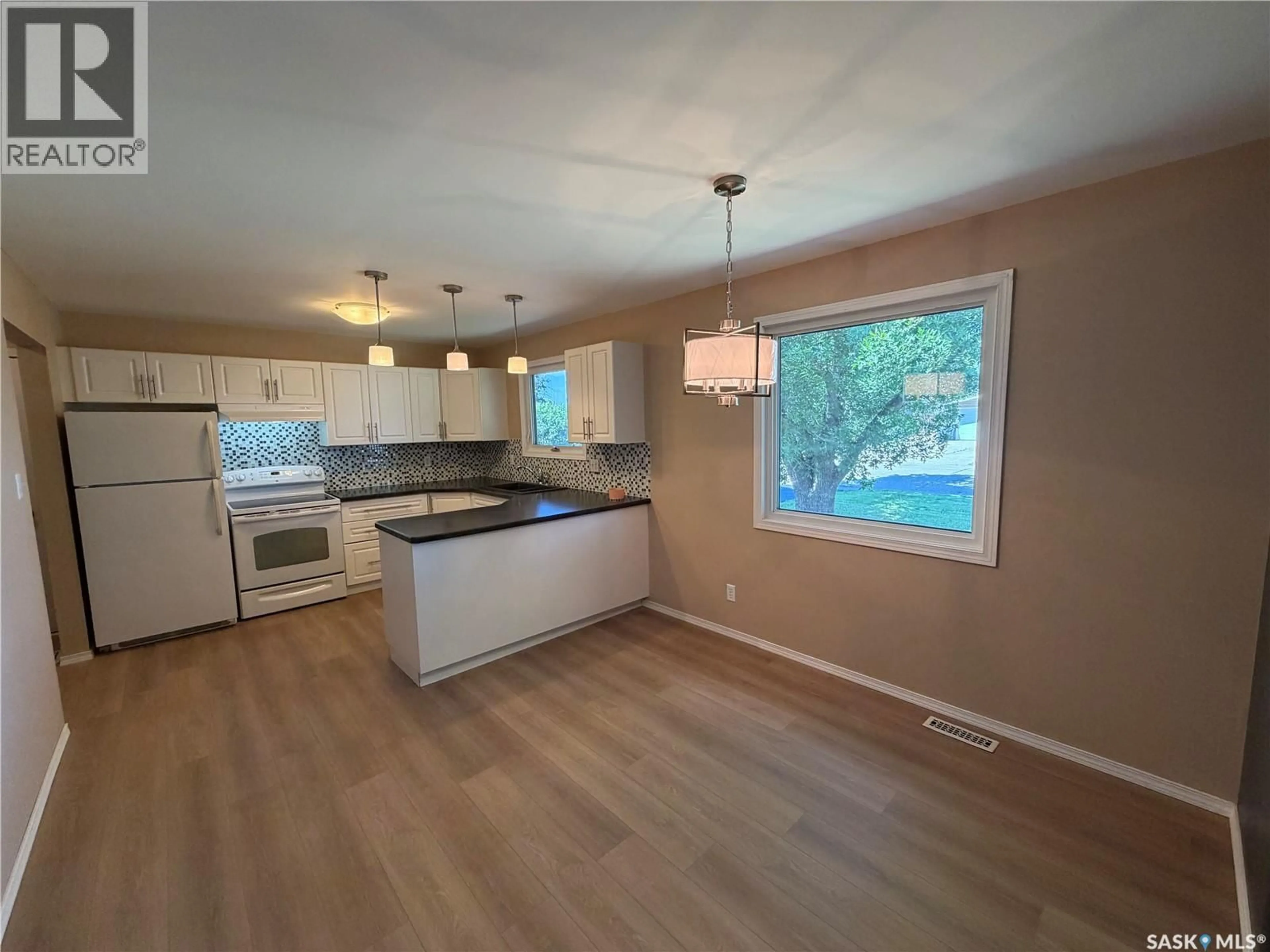 Open concept kitchen, wood/laminate floor for 25 SOURIS AVENUE, Redvers Saskatchewan S0C0A5