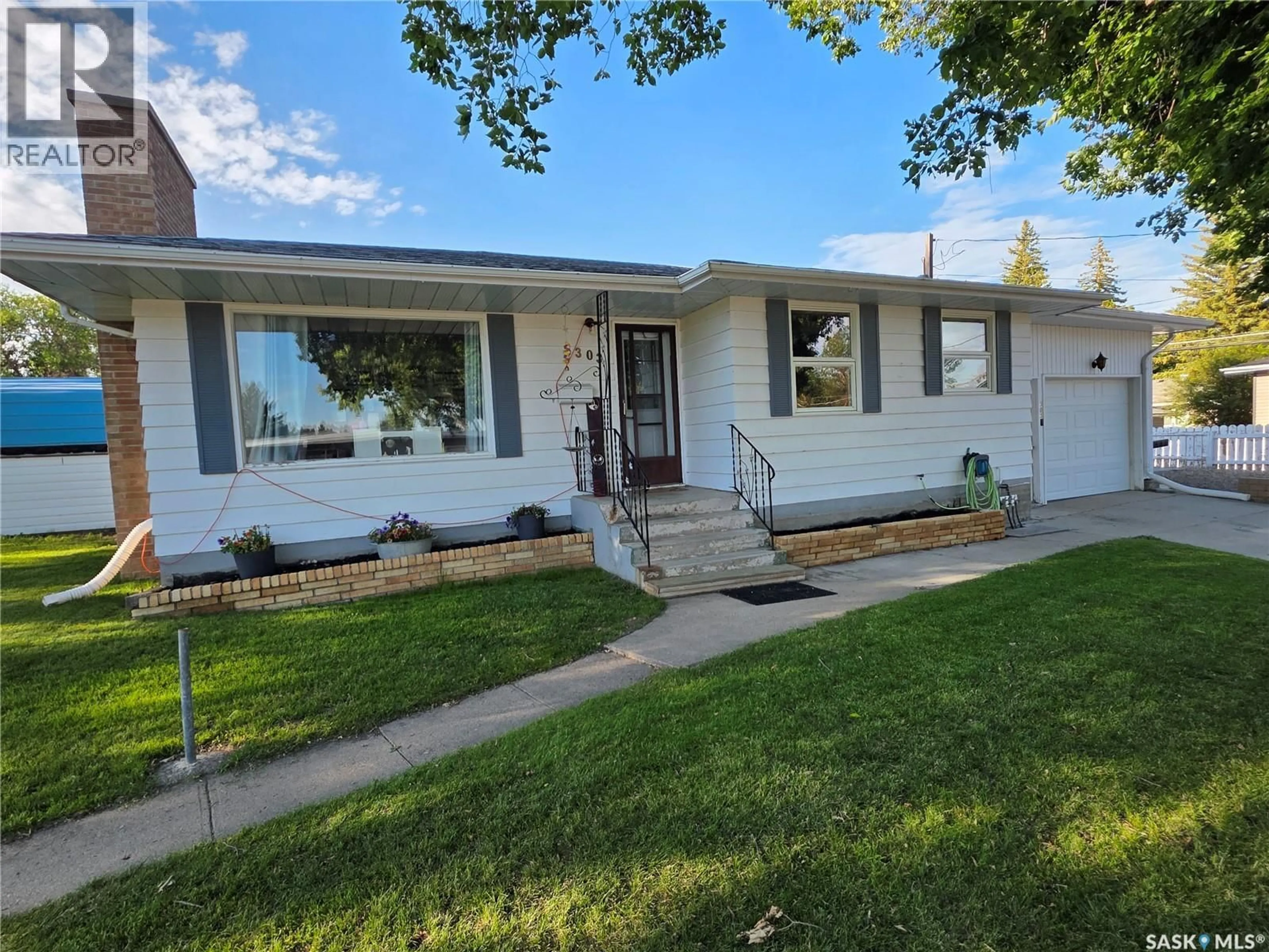 Home with vinyl exterior material, street for 303 13TH AVENUE, Swift Current Saskatchewan S9H2V9