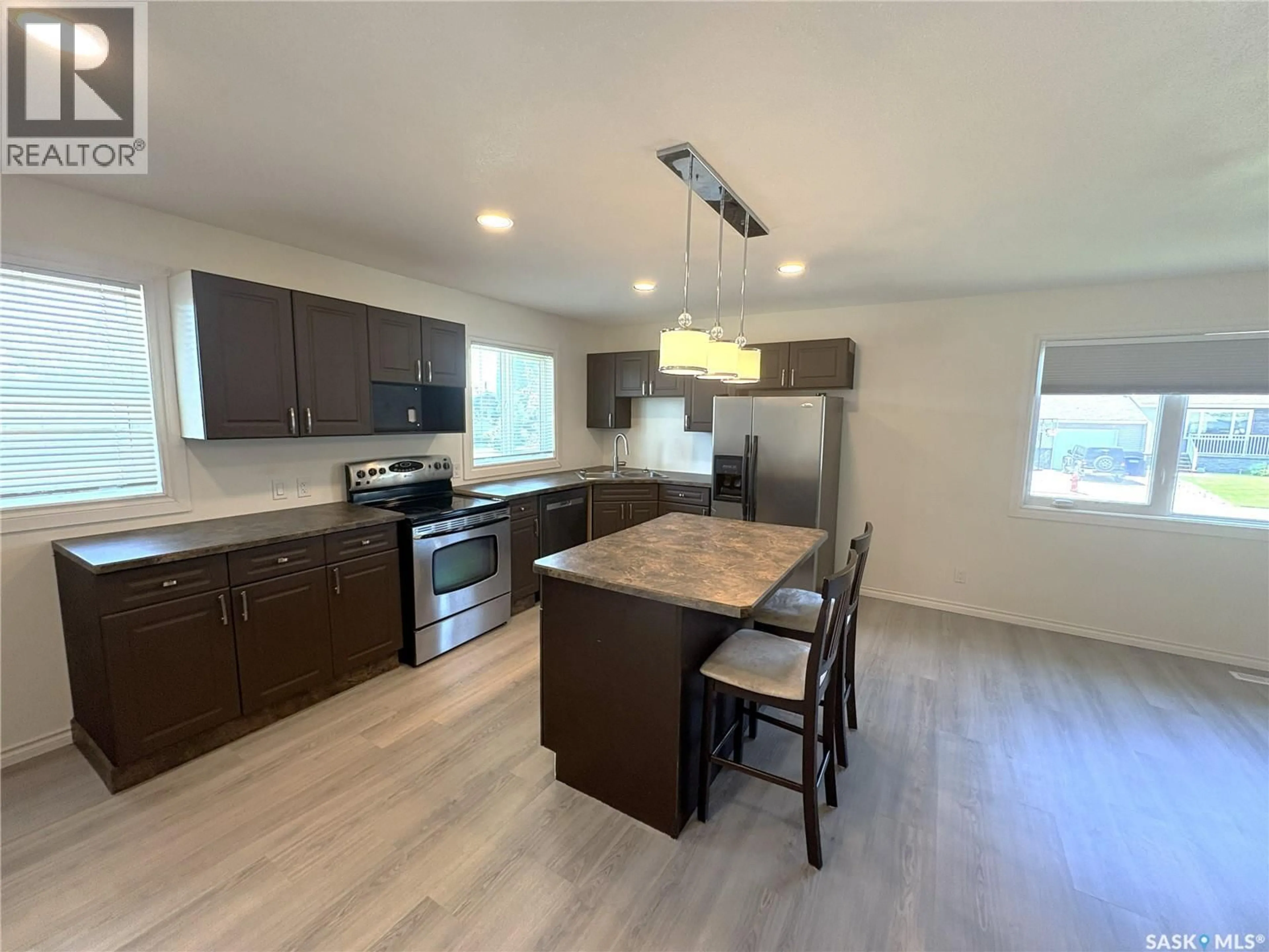 Open concept kitchen, wood/laminate floor for 27 CALVERT CRESCENT, Lanigan Saskatchewan S0K2M0