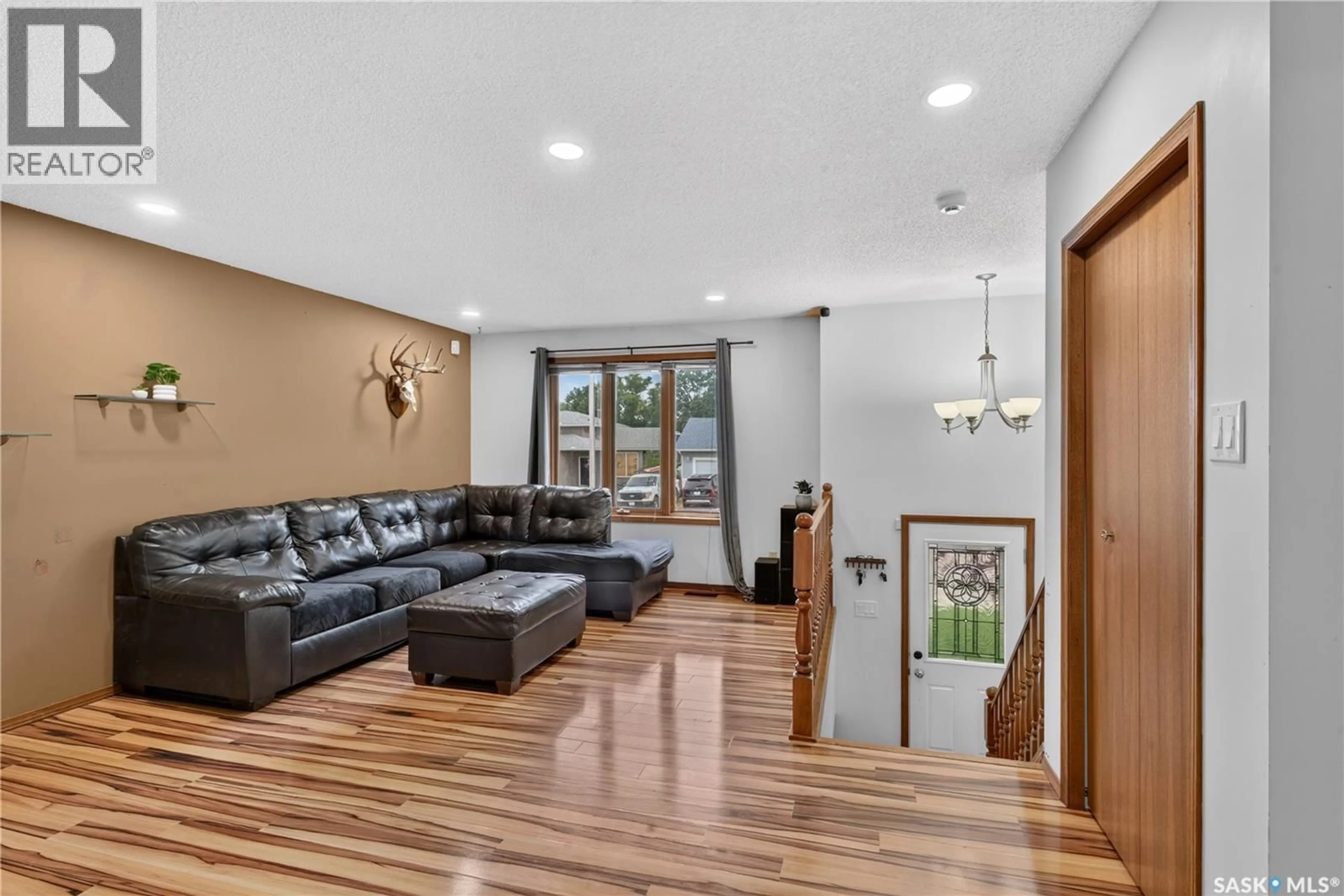Living room with furniture, wood/laminate floor for 417 FEHR CRESCENT, Martensville Saskatchewan S0K2T0