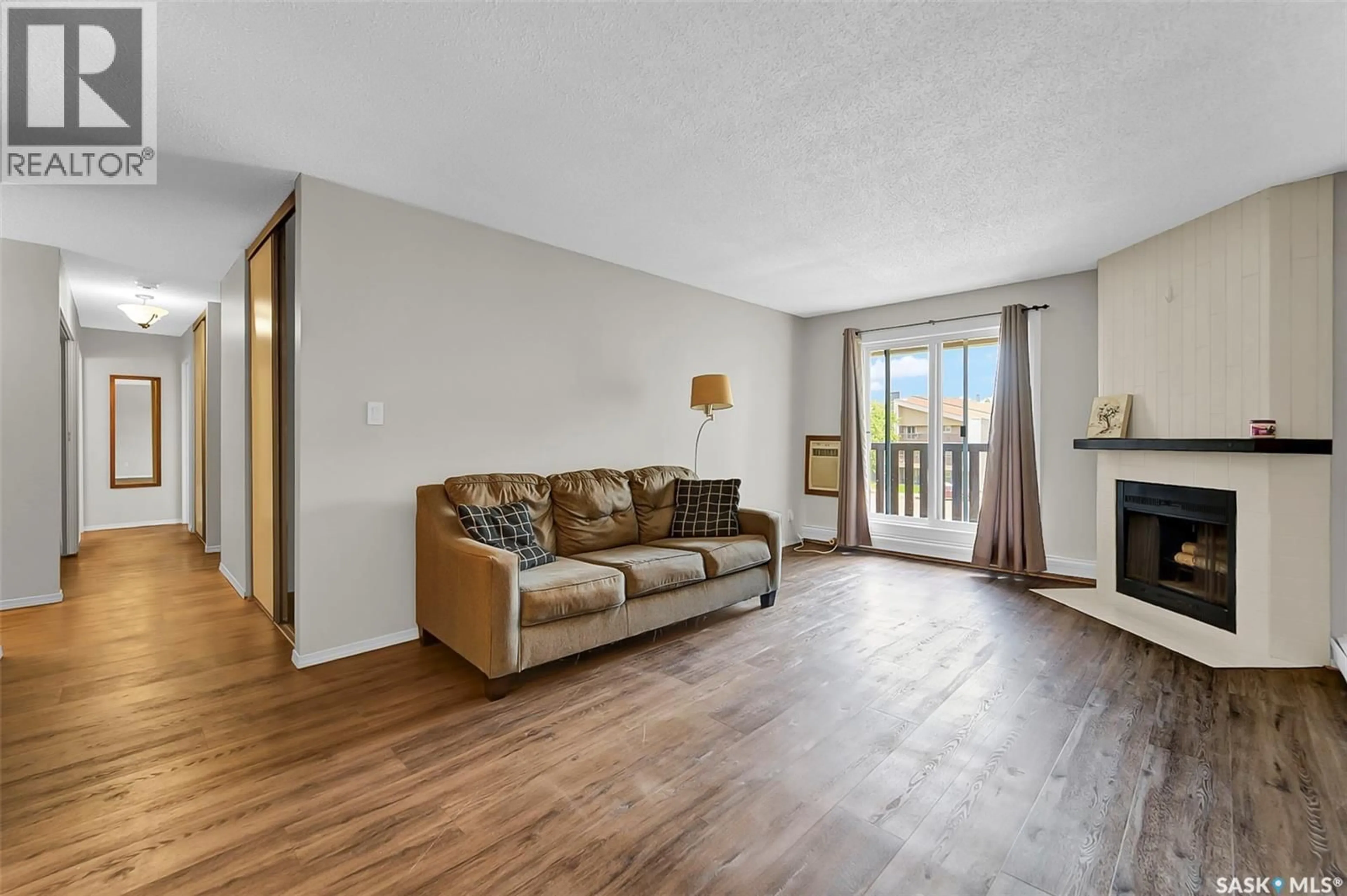 Living room with furniture, wood/laminate floor for 510 - 630 PRAIRIE AVENUE, Saskatoon Saskatchewan S7N2V4