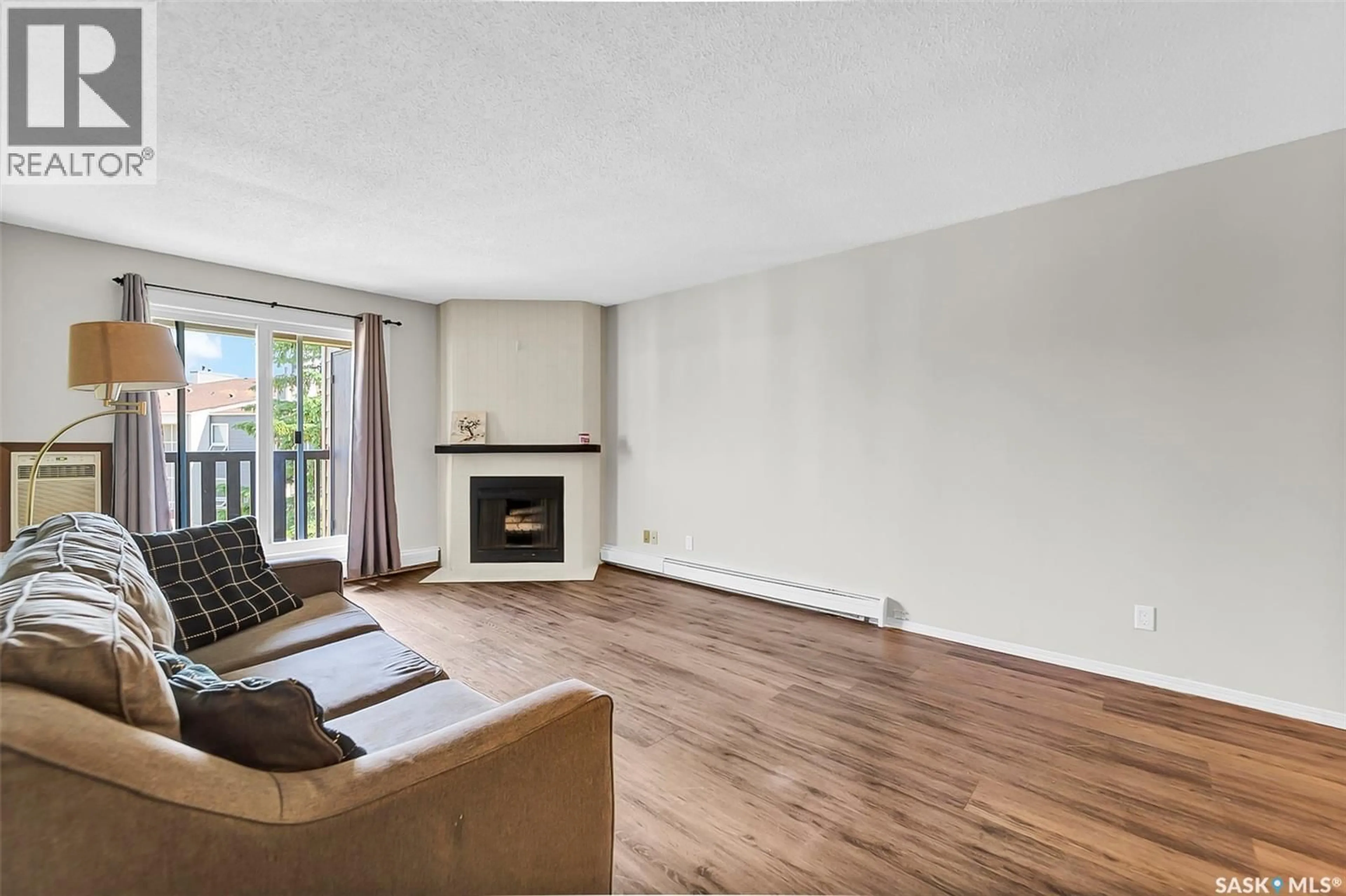 Living room with furniture, wood/laminate floor for 510 - 630 PRAIRIE AVENUE, Saskatoon Saskatchewan S7N2V4