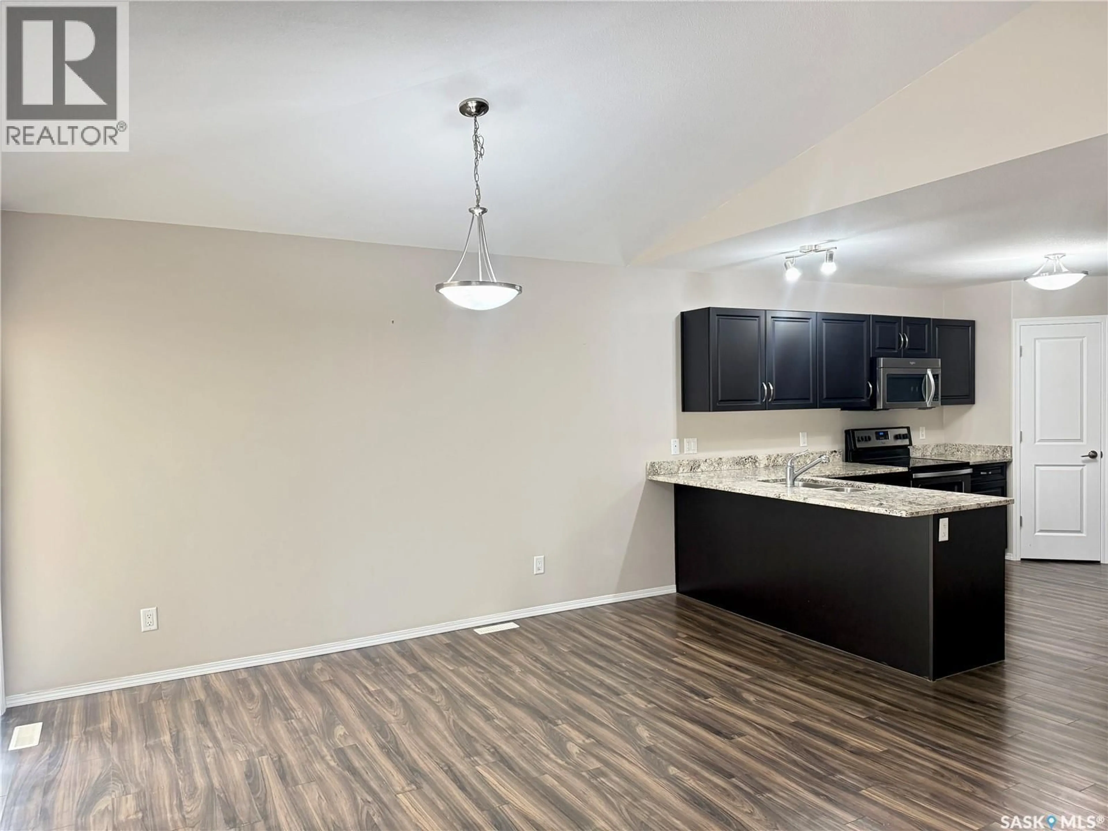 Open concept kitchen, wood/laminate floor for 100 - 331 CHAPARRAL BOULEVARD, Martensville Saskatchewan S0K0A2