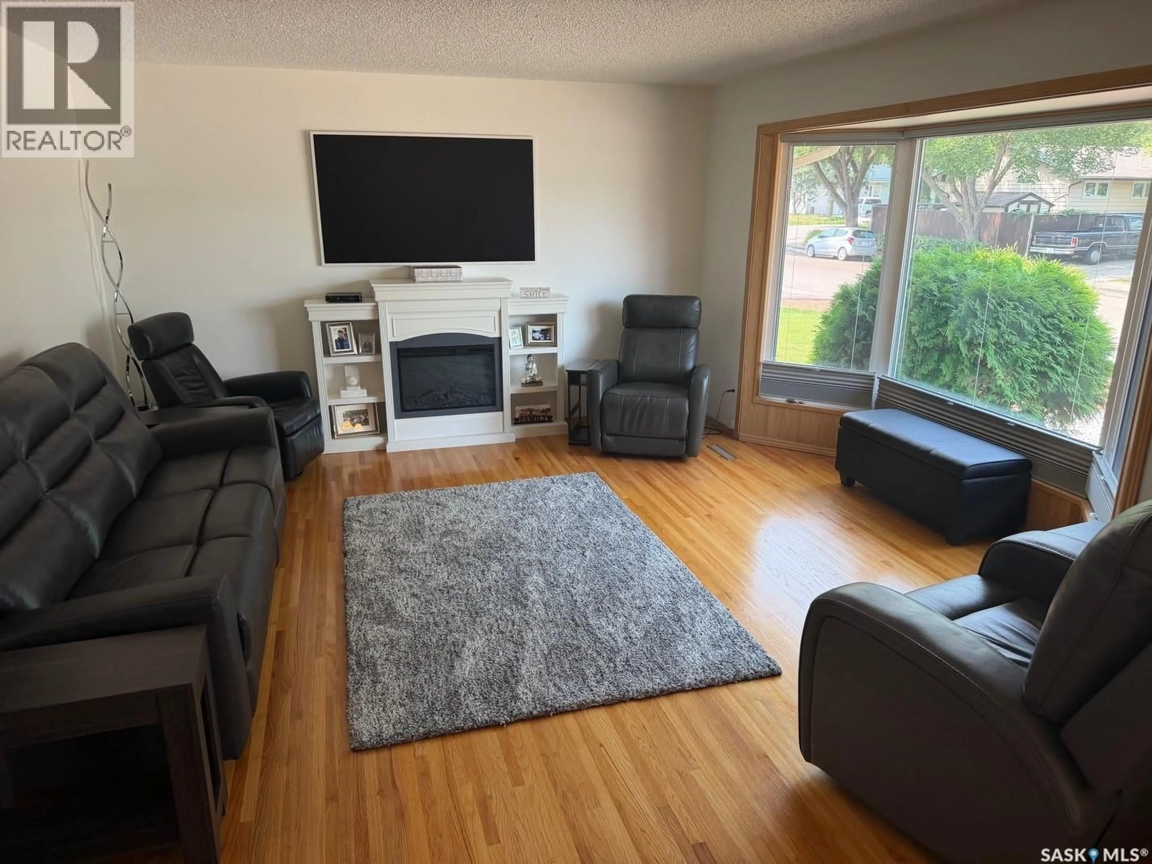 Living room with furniture, wood/laminate floor for 107 MERLIN CRESCENT, Regina Saskatchewan S4R3E6