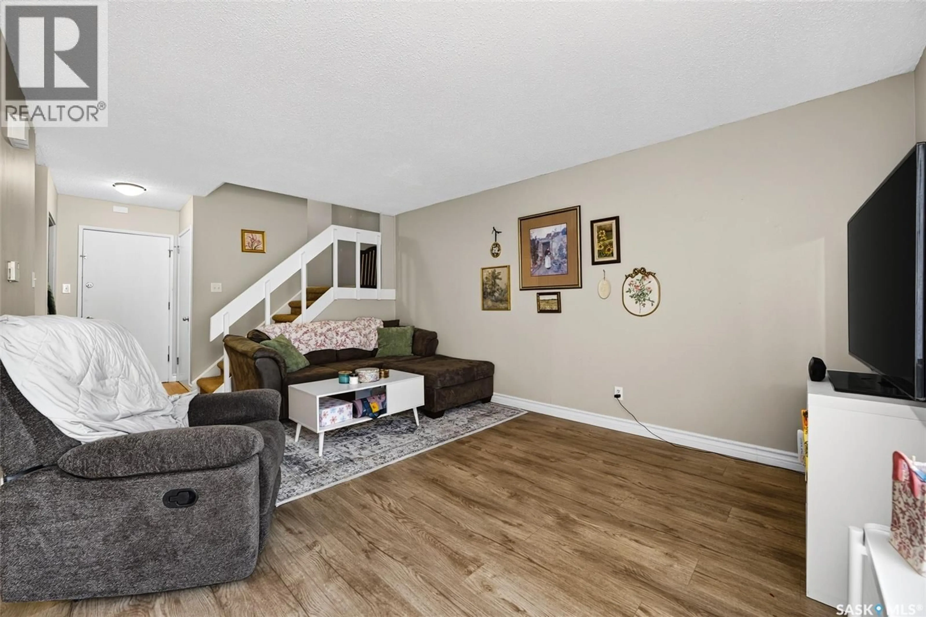 Living room with furniture, wood/laminate floor for 4216 CASTLE ROAD, Regina Saskatchewan S4S4W1