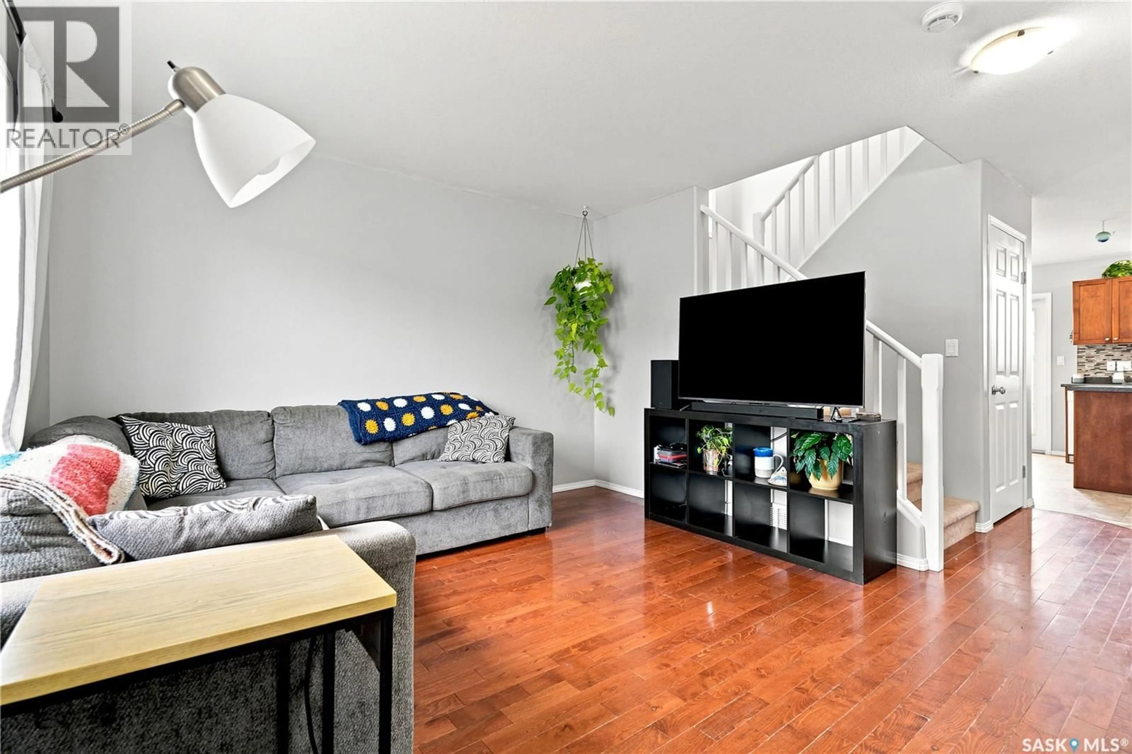 Living room with furniture, wood/laminate floor for 435 BLAKENEY CRESCENT, Saskatoon Saskatchewan S7L7N5