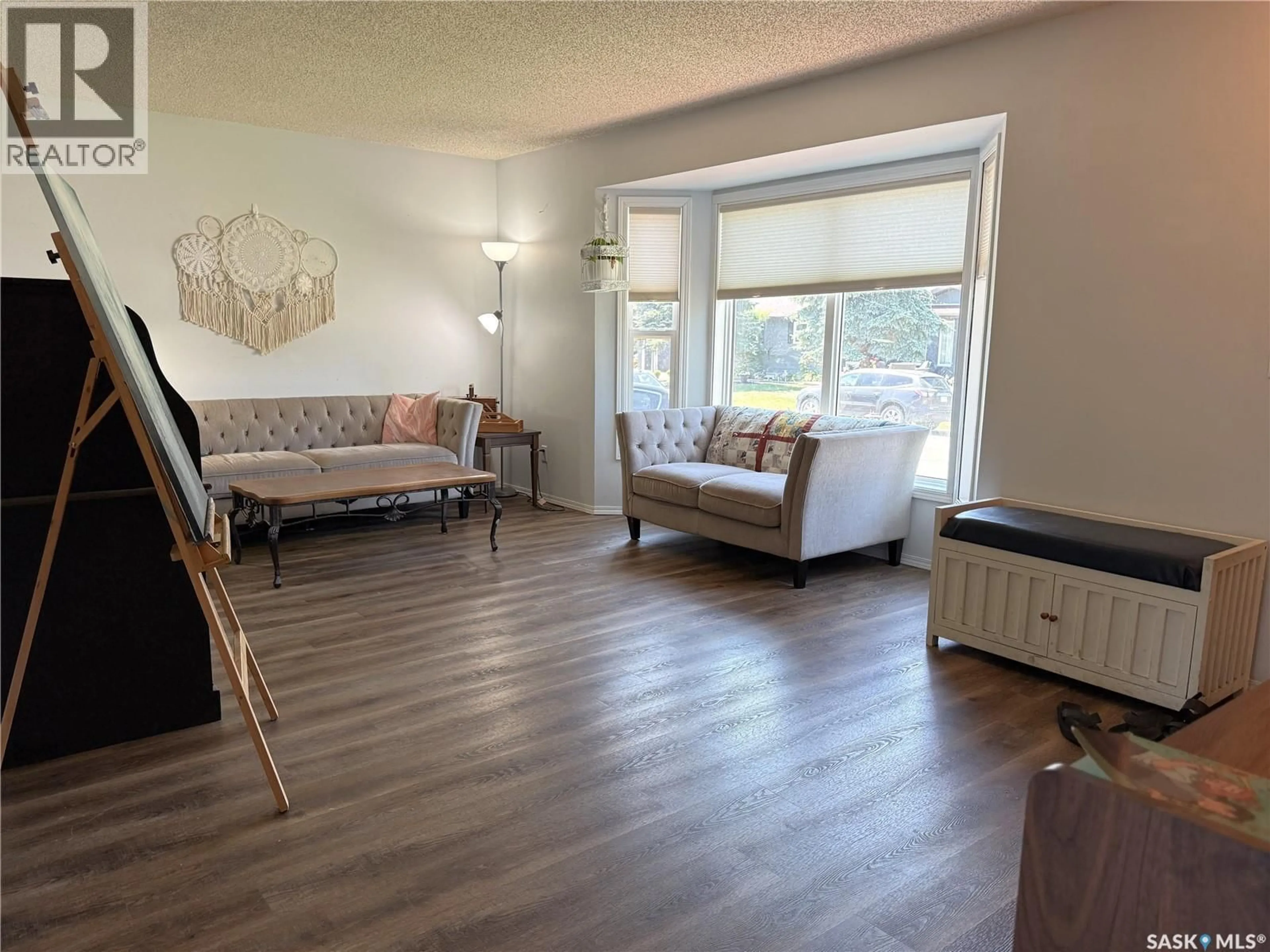 Living room with furniture, wood/laminate floor for 207 MAPLE STREET, Outlook Saskatchewan S0L2N0