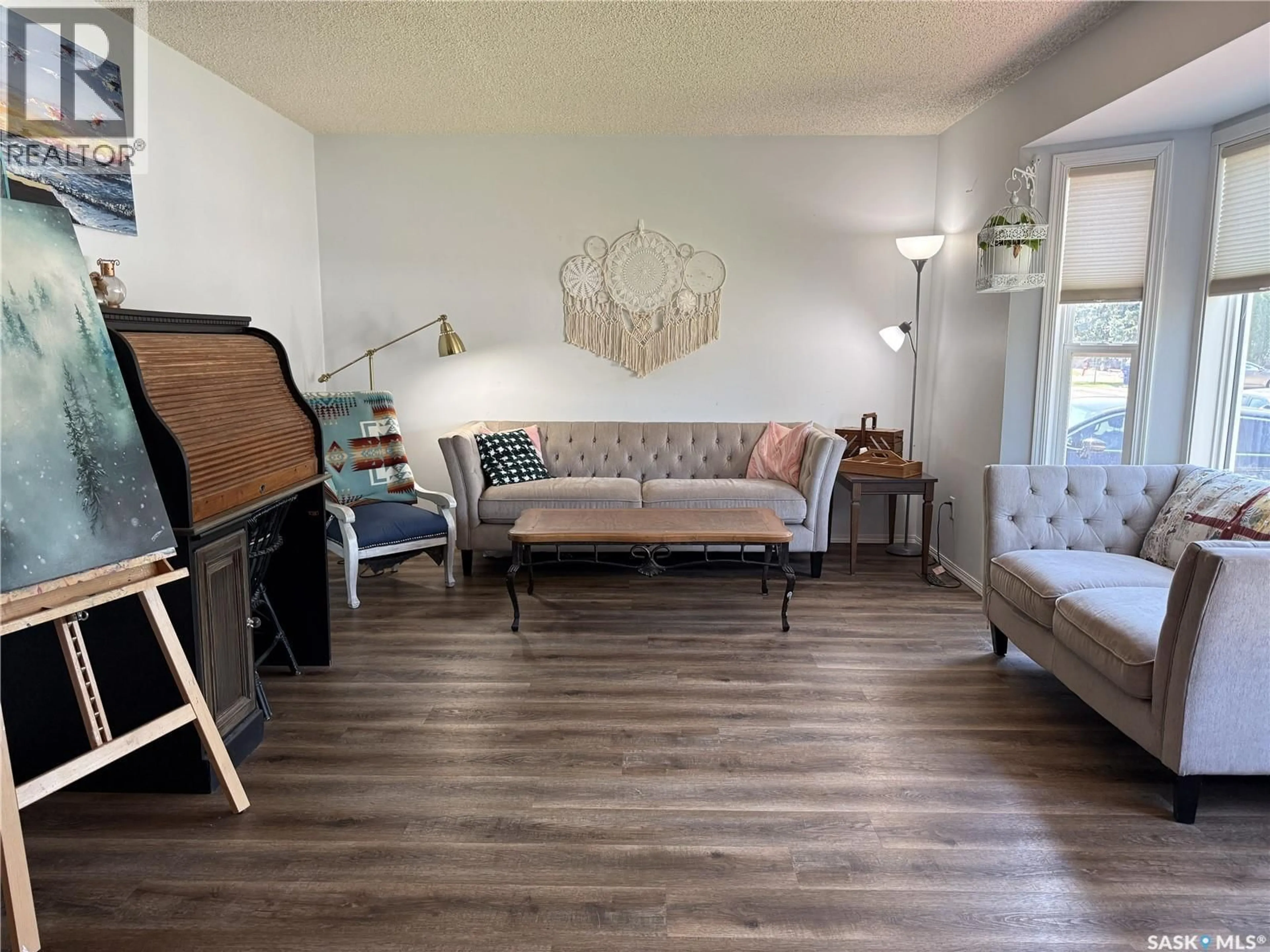 Living room with furniture, wood/laminate floor for 207 MAPLE STREET, Outlook Saskatchewan S0L2N0