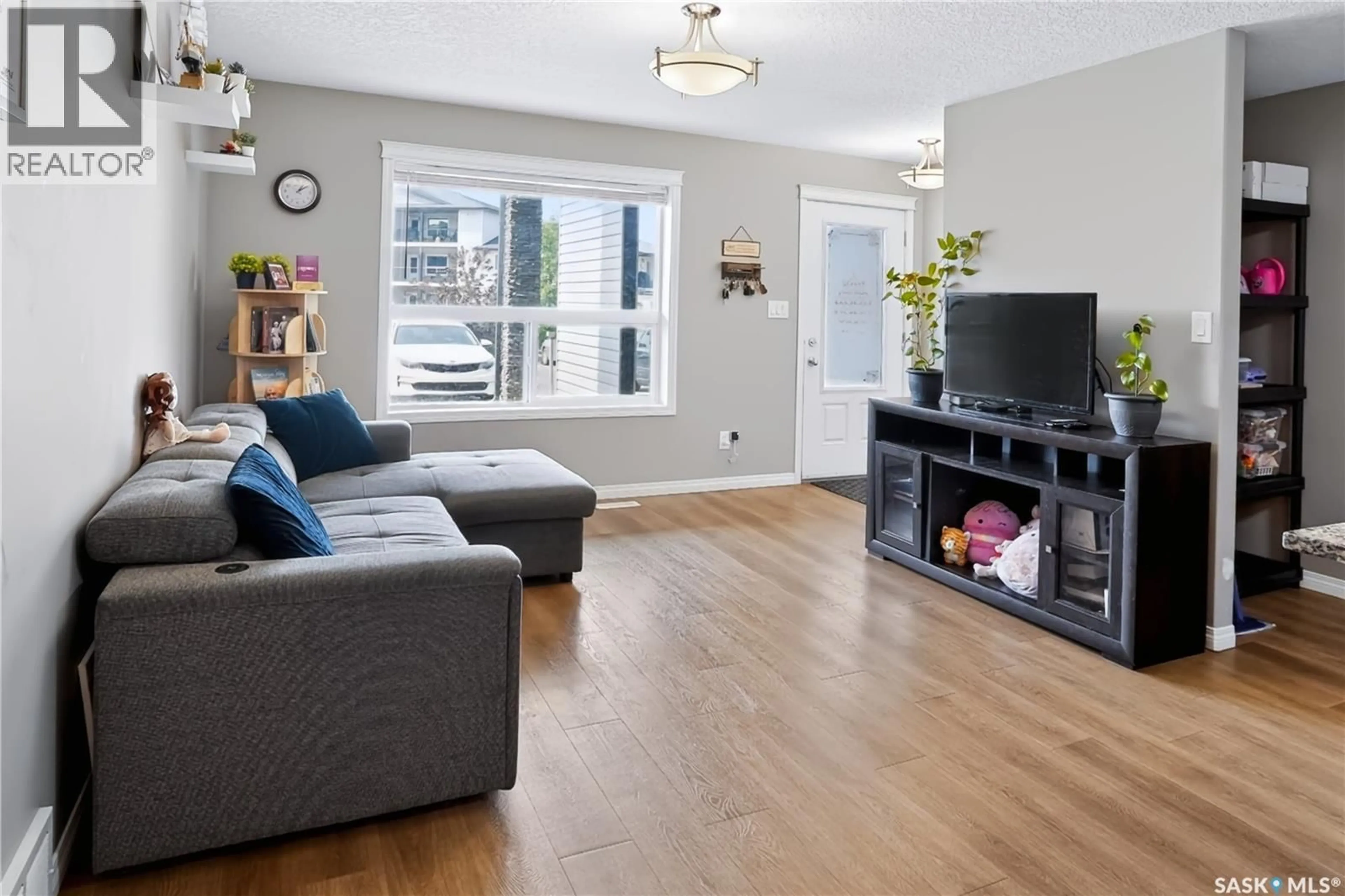 Living room with furniture, wood/laminate floor for 125 - 113 WILLIS CRESCENT, Saskatoon Saskatchewan S7T0T1