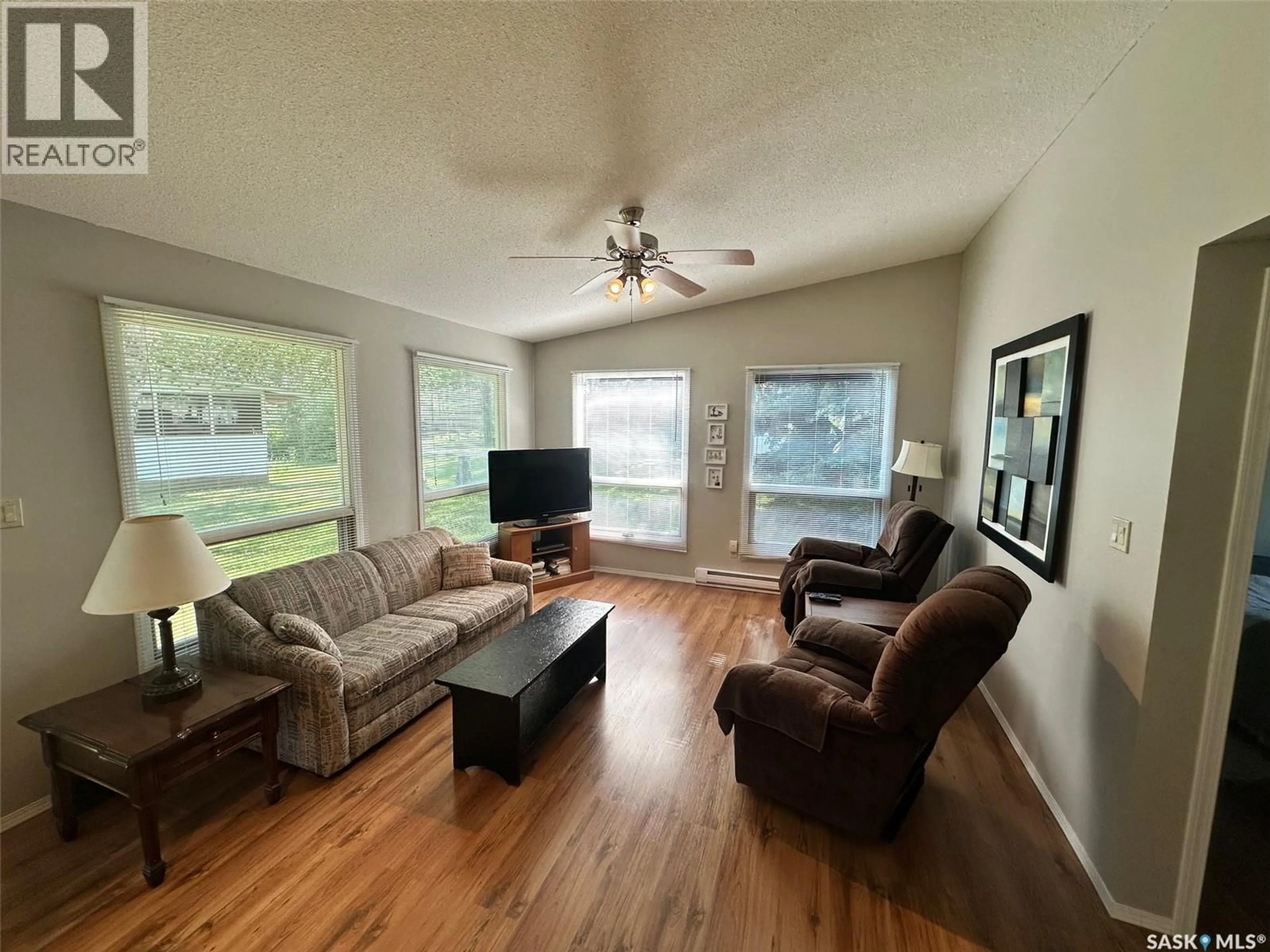 Living room with furniture, wood/laminate floor for 24 RUBY CRESCENT, Hudson Bay Rm No. 394 Saskatchewan S0E0Y0