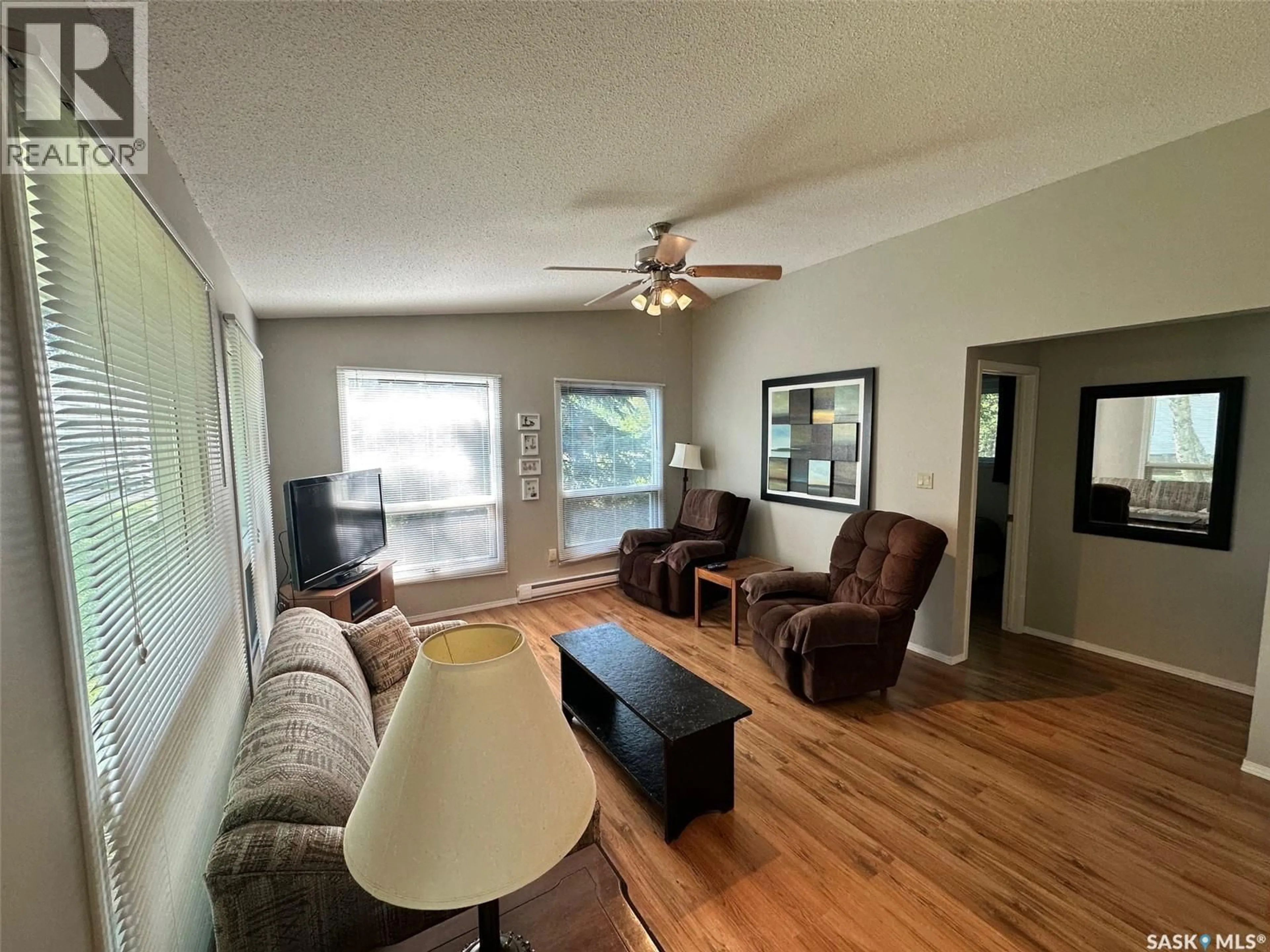 Living room with furniture, wood/laminate floor for 24 RUBY CRESCENT, Hudson Bay Rm No. 394 Saskatchewan S0E0Y0