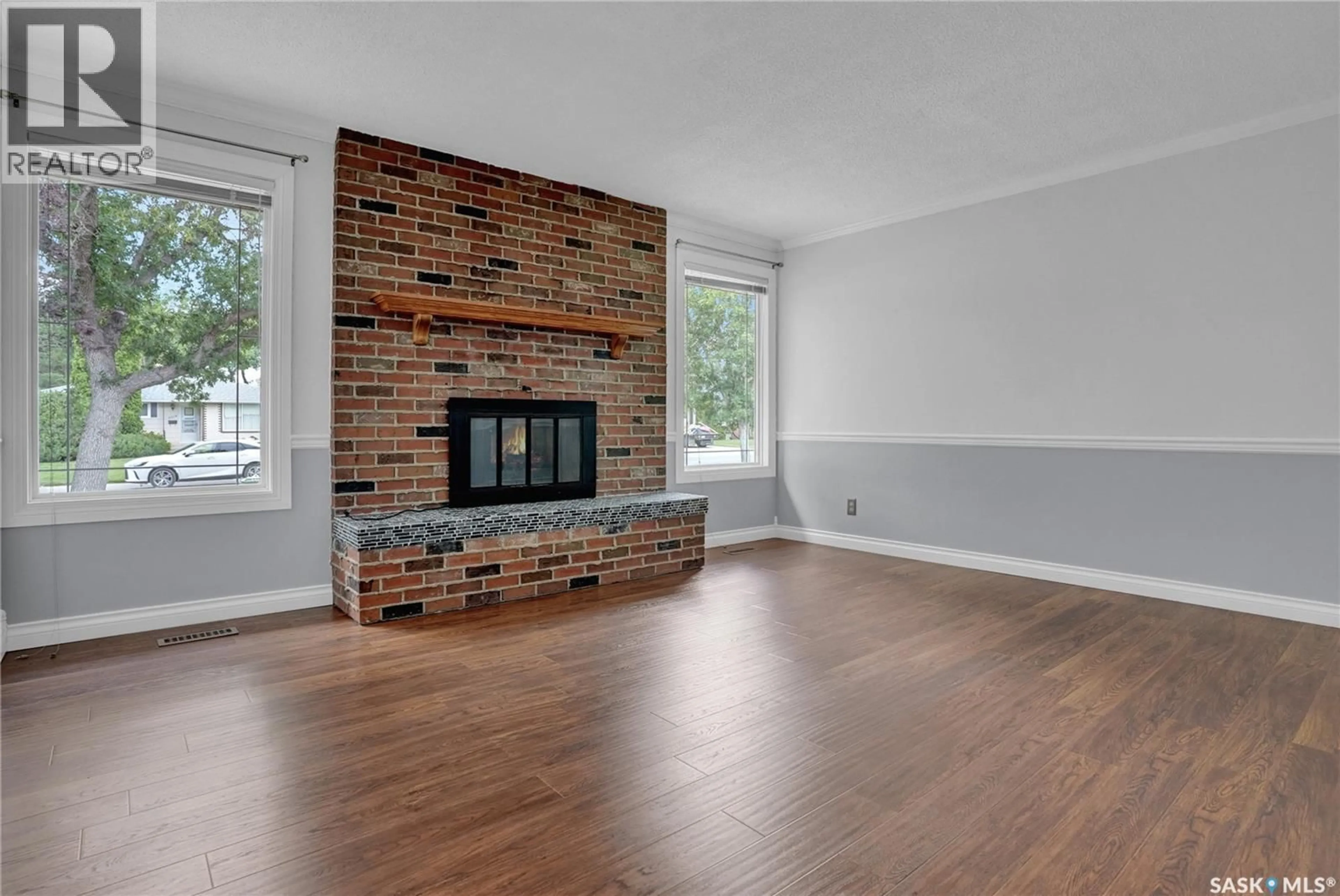 Living room with furniture, wood/laminate floor for 6015 7TH AVENUE, Regina Saskatchewan S4T6X2