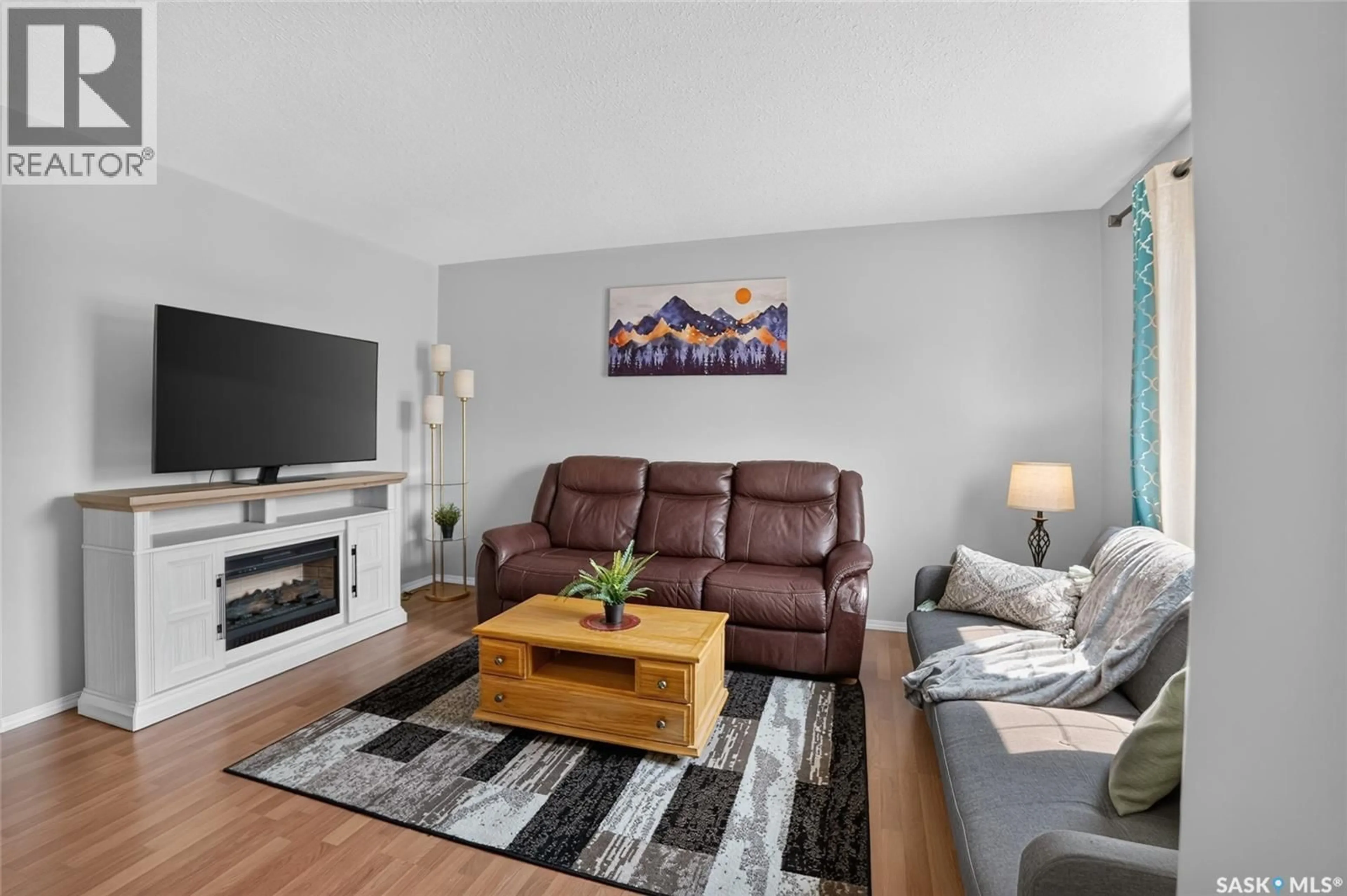 Living room with furniture, wood/laminate floor for 102 - 13 PAWLYCHENKO LANE, Saskatoon Saskatchewan S7V1G9