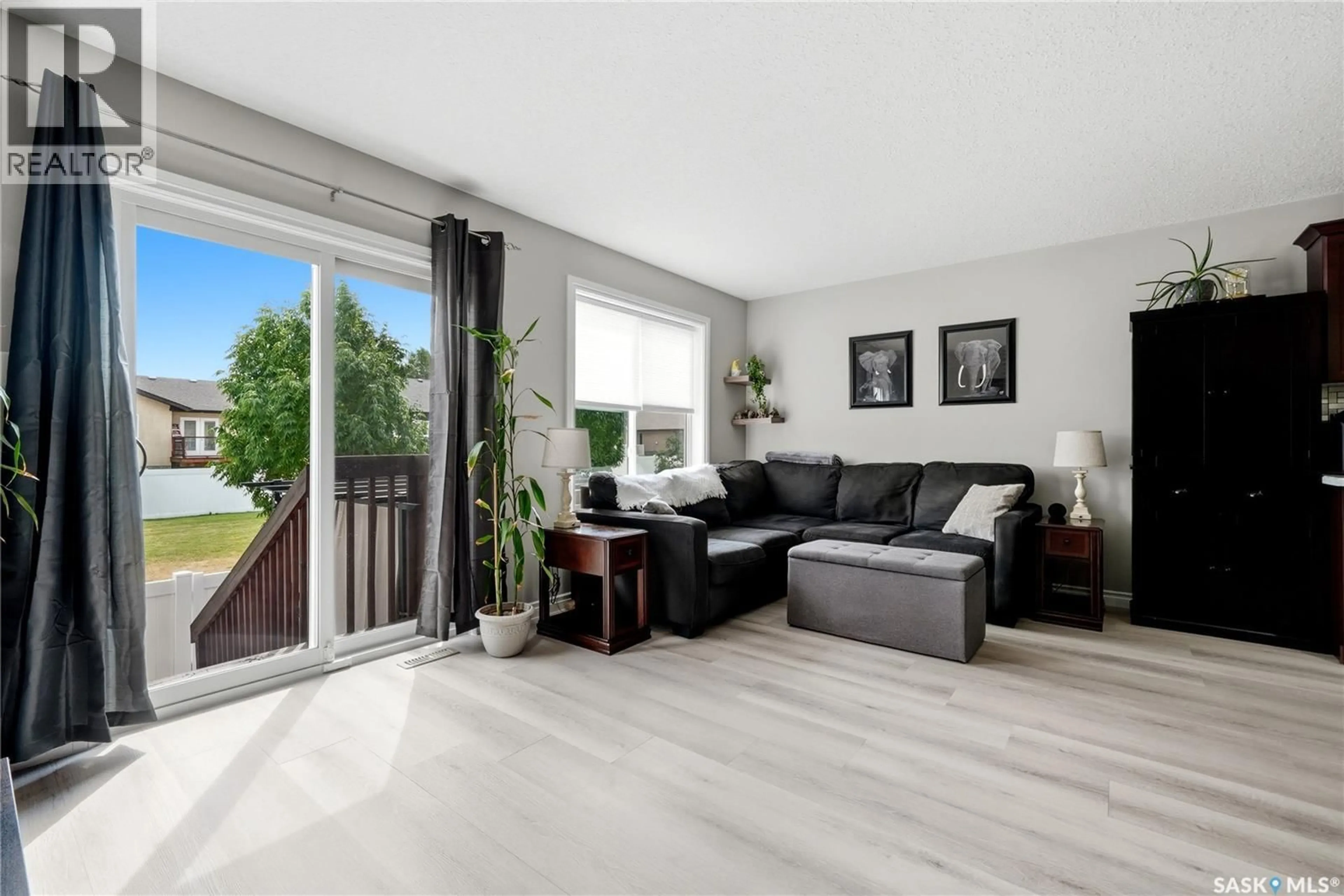 Living room with furniture, wood/laminate floor for 105 PLAINS CIRCLE, Pilot Butte Saskatchewan S0G3Z0