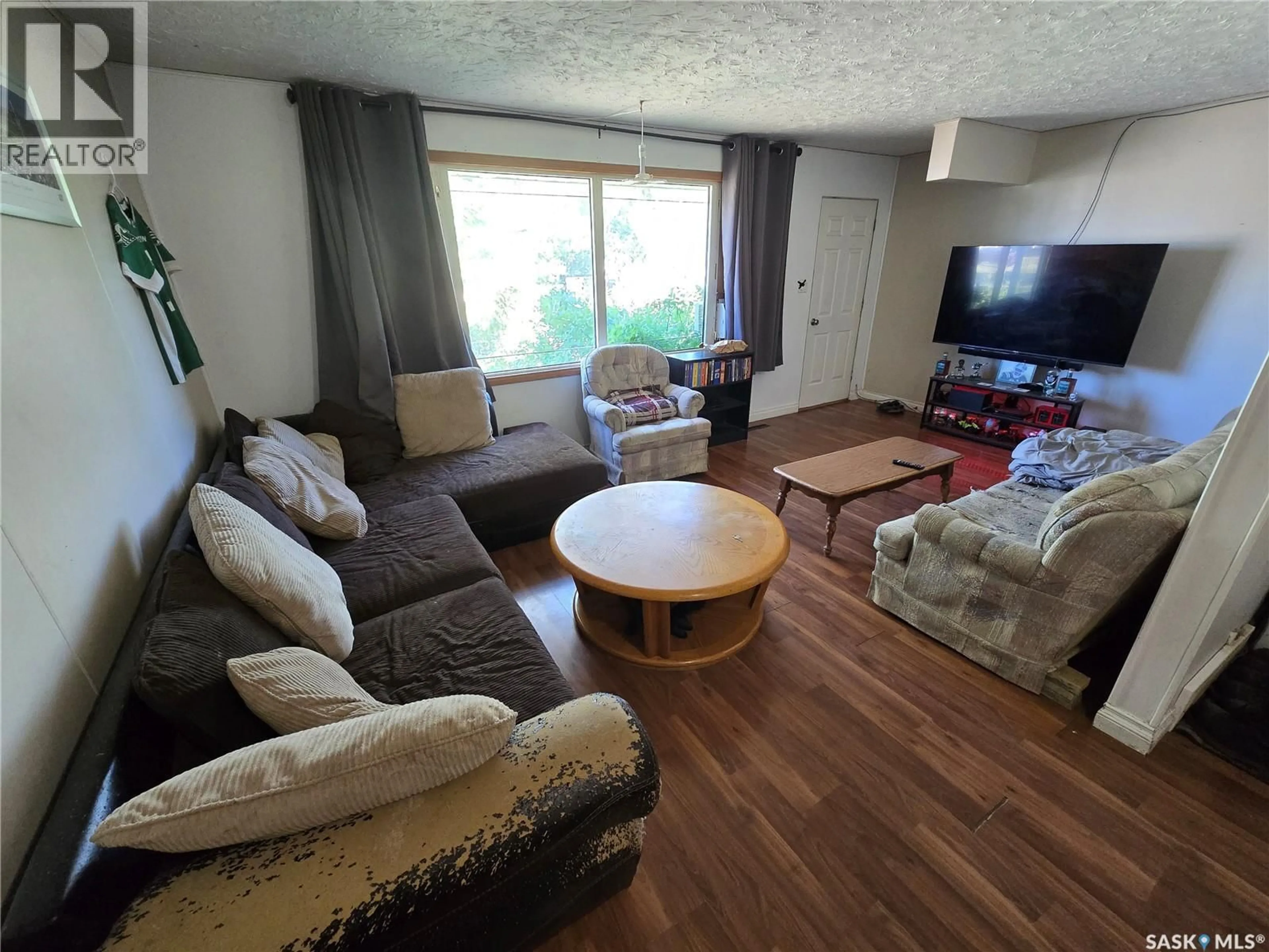 Living room with furniture, wood/laminate floor for 618 3RD STREET, Weyburn Saskatchewan S4H2E1