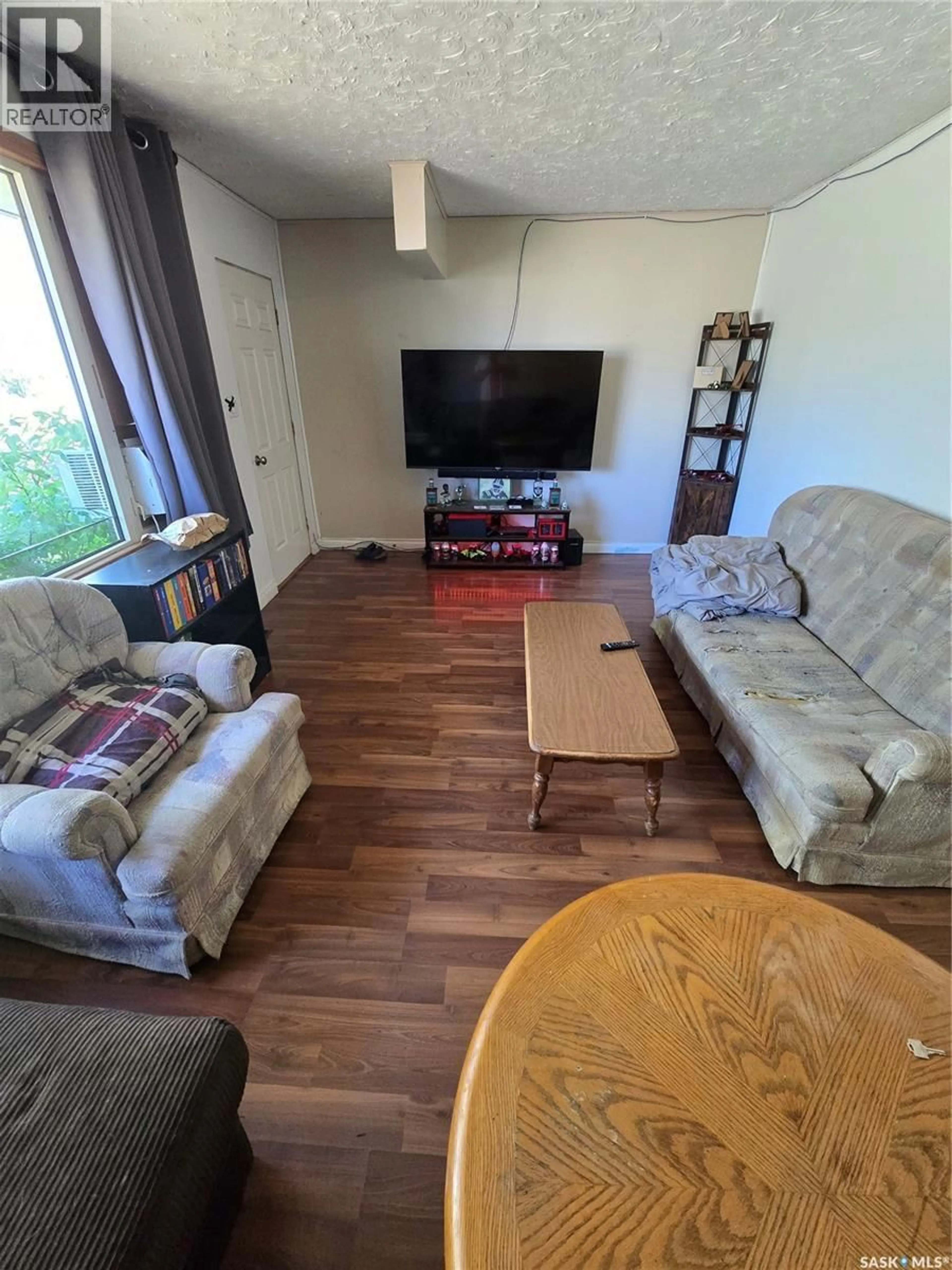Living room with furniture, wood/laminate floor for 618 3RD STREET, Weyburn Saskatchewan S4H2E1