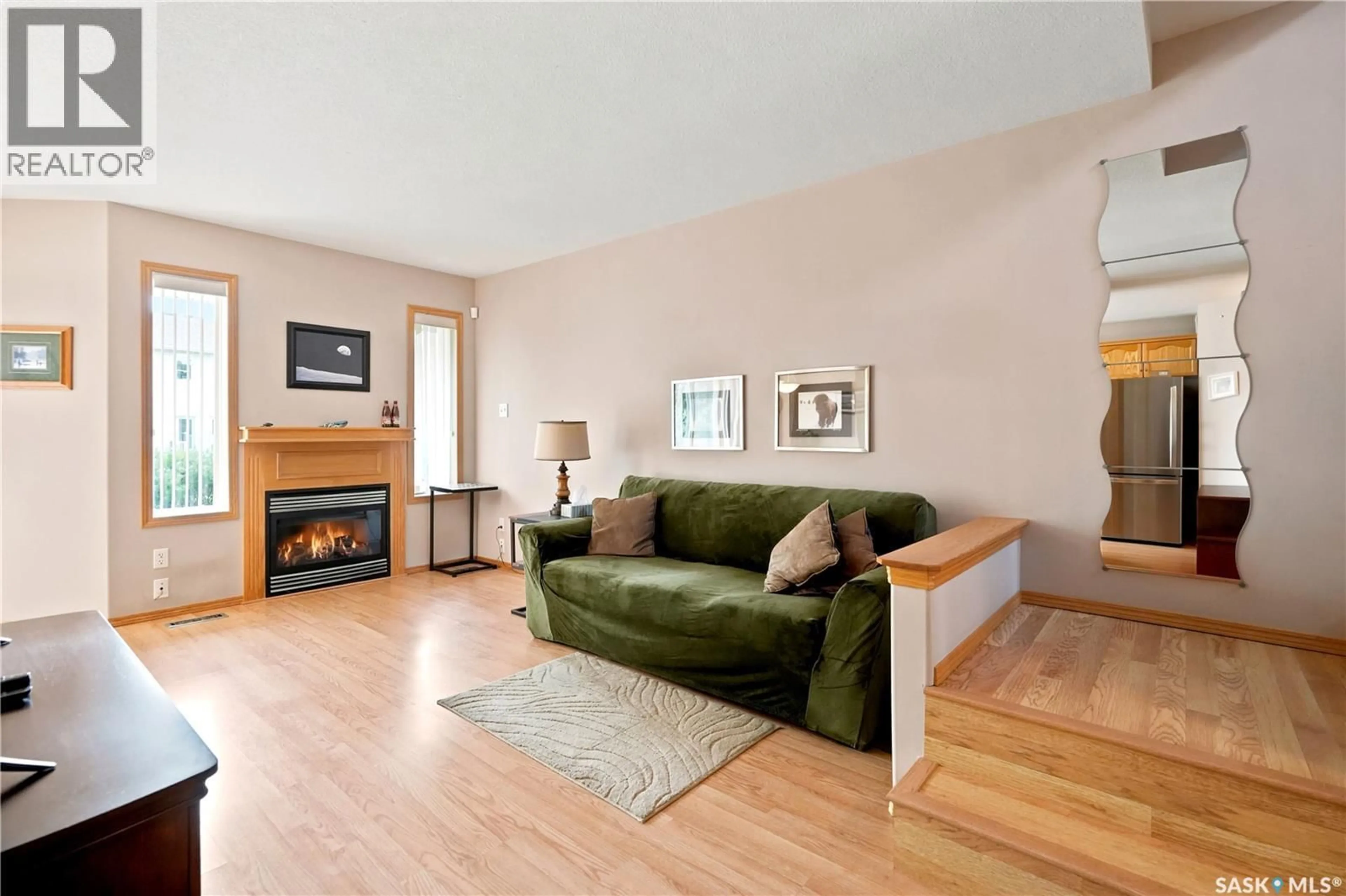 Living room with furniture, wood/laminate floor for 225 MIKKELSON DRIVE, Regina Saskatchewan S4T7X9