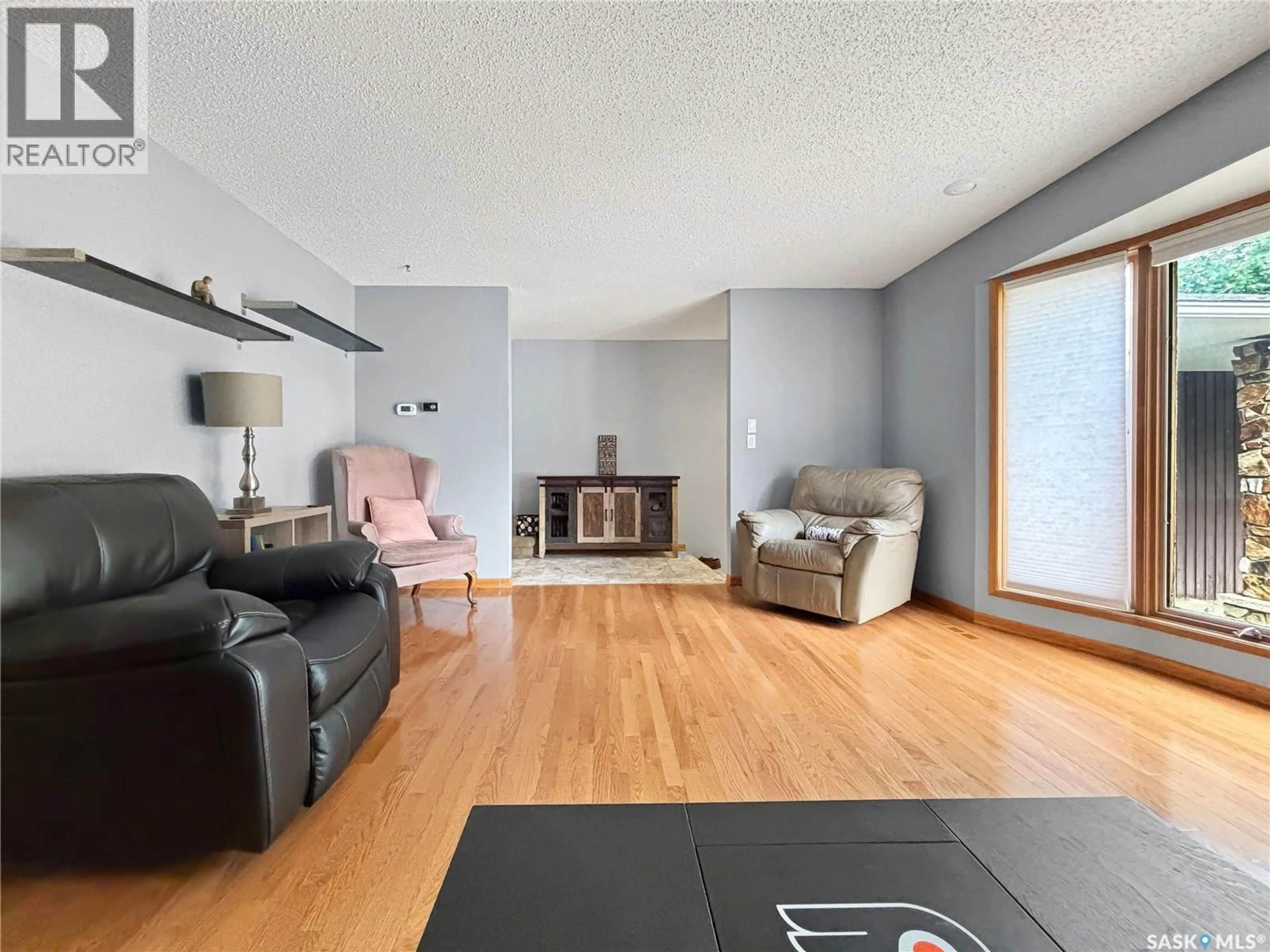 Living room with furniture, wood/laminate floor for 407 CHITEK CRESCENT, Saskatoon Saskatchewan S7K5C1