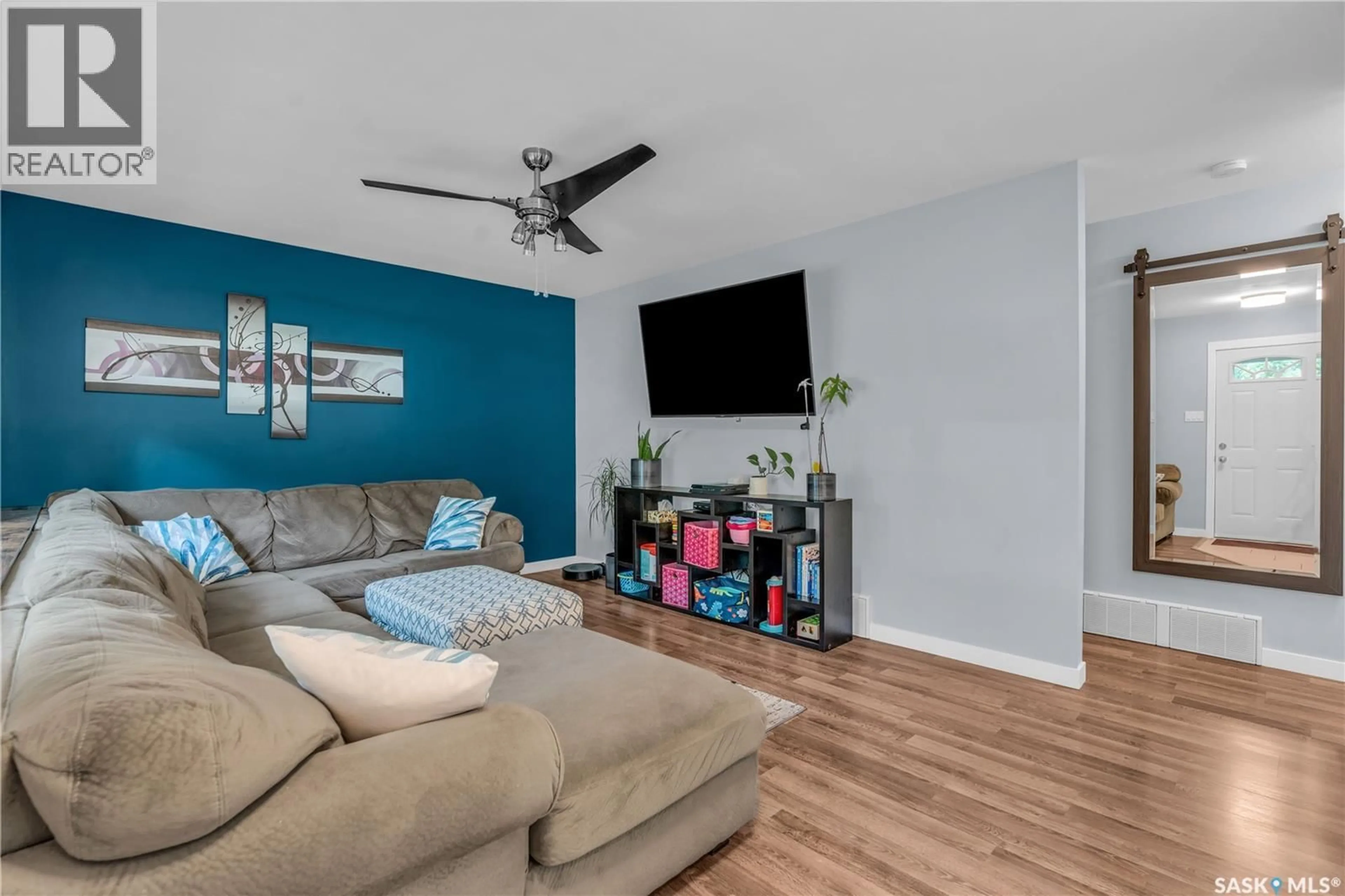 Living room with furniture, wood/laminate floor for 26 FYFE STREET, Regina Saskatchewan S4X1J8