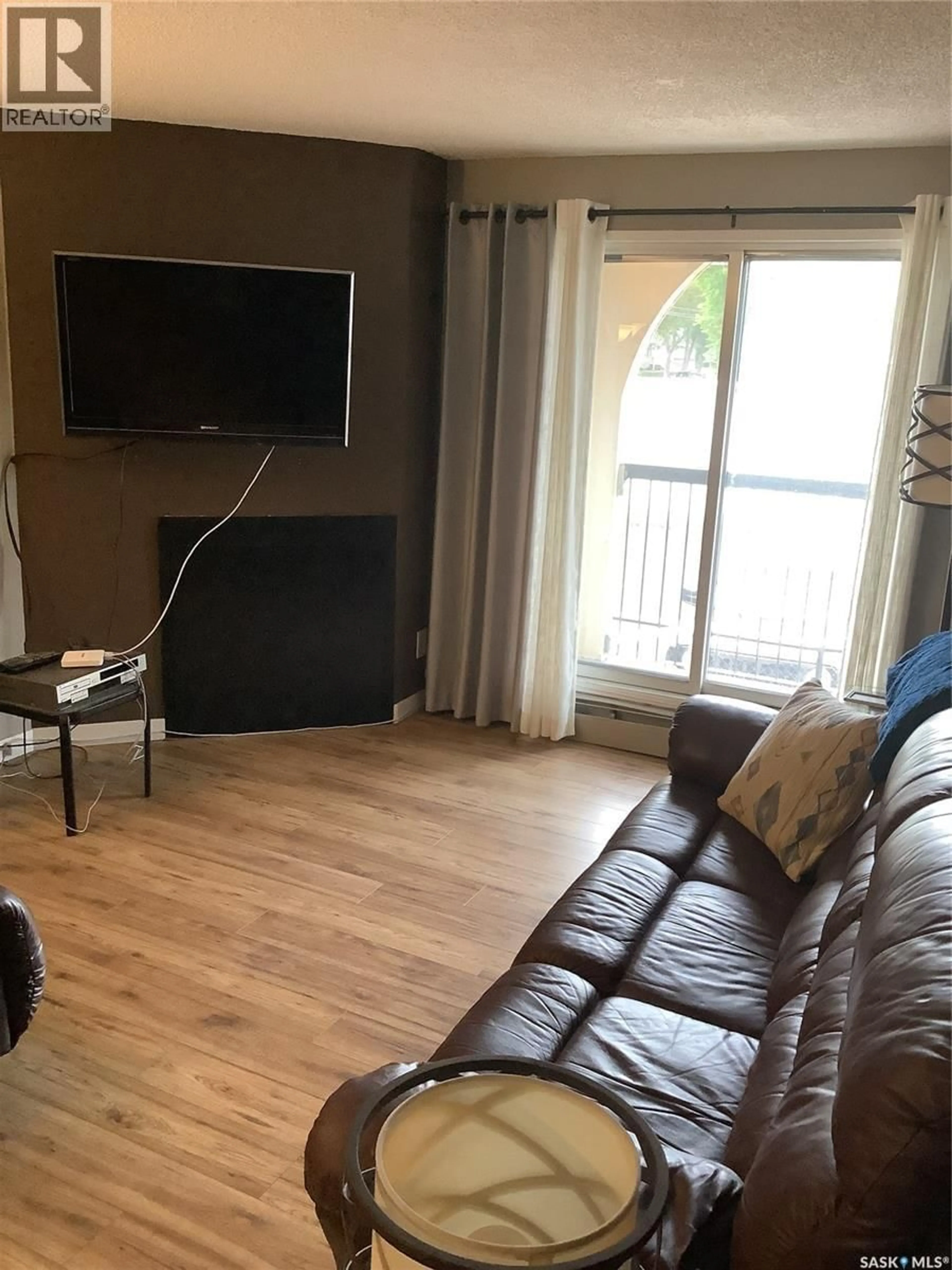 Living room with furniture, wood/laminate floor for 204 - 610 HILLIARD STREET, Saskatoon Saskatchewan S7M5L5