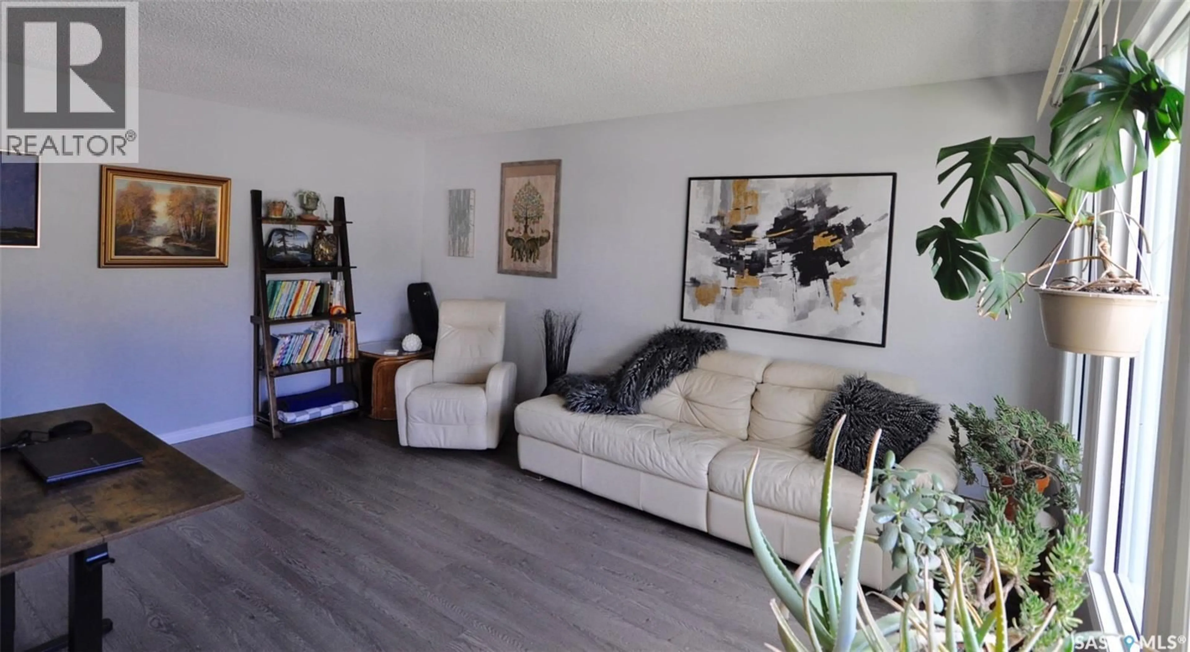 Living room with furniture, wood/laminate floor for 407 WATHAMAN CRESCENT, Saskatoon Saskatchewan S7K4P8