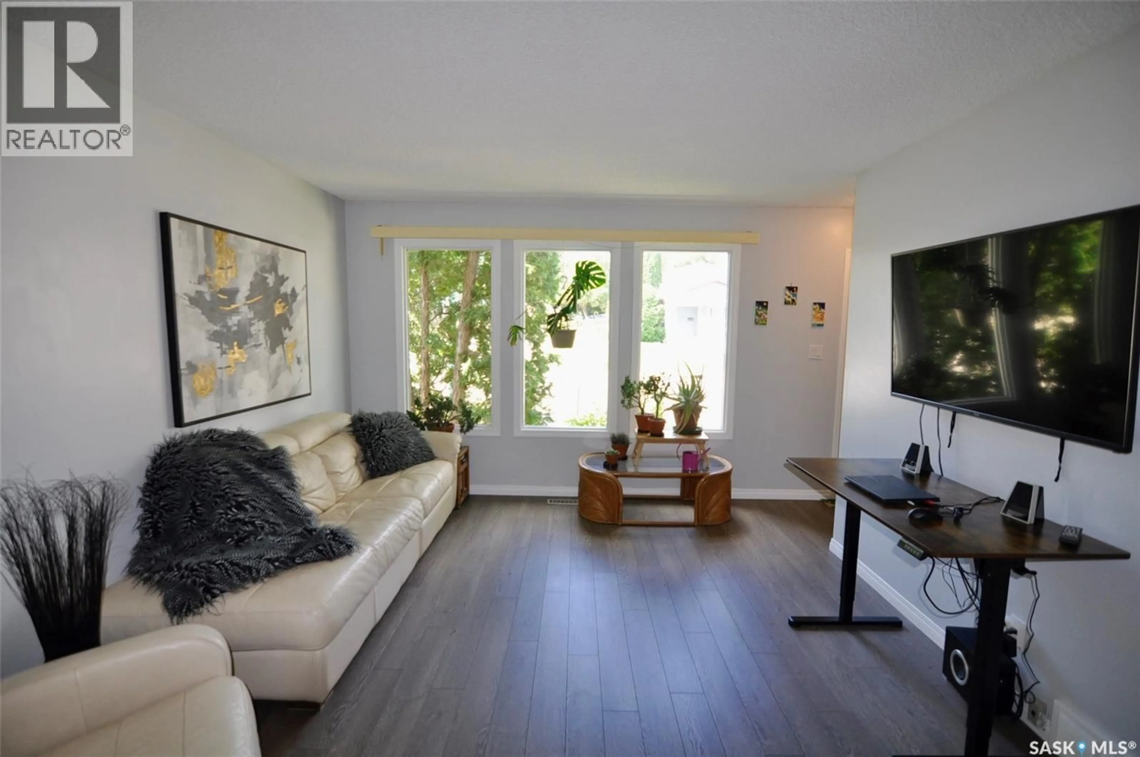 Living room with furniture, wood/laminate floor for 407 WATHAMAN CRESCENT, Saskatoon Saskatchewan S7K4P8