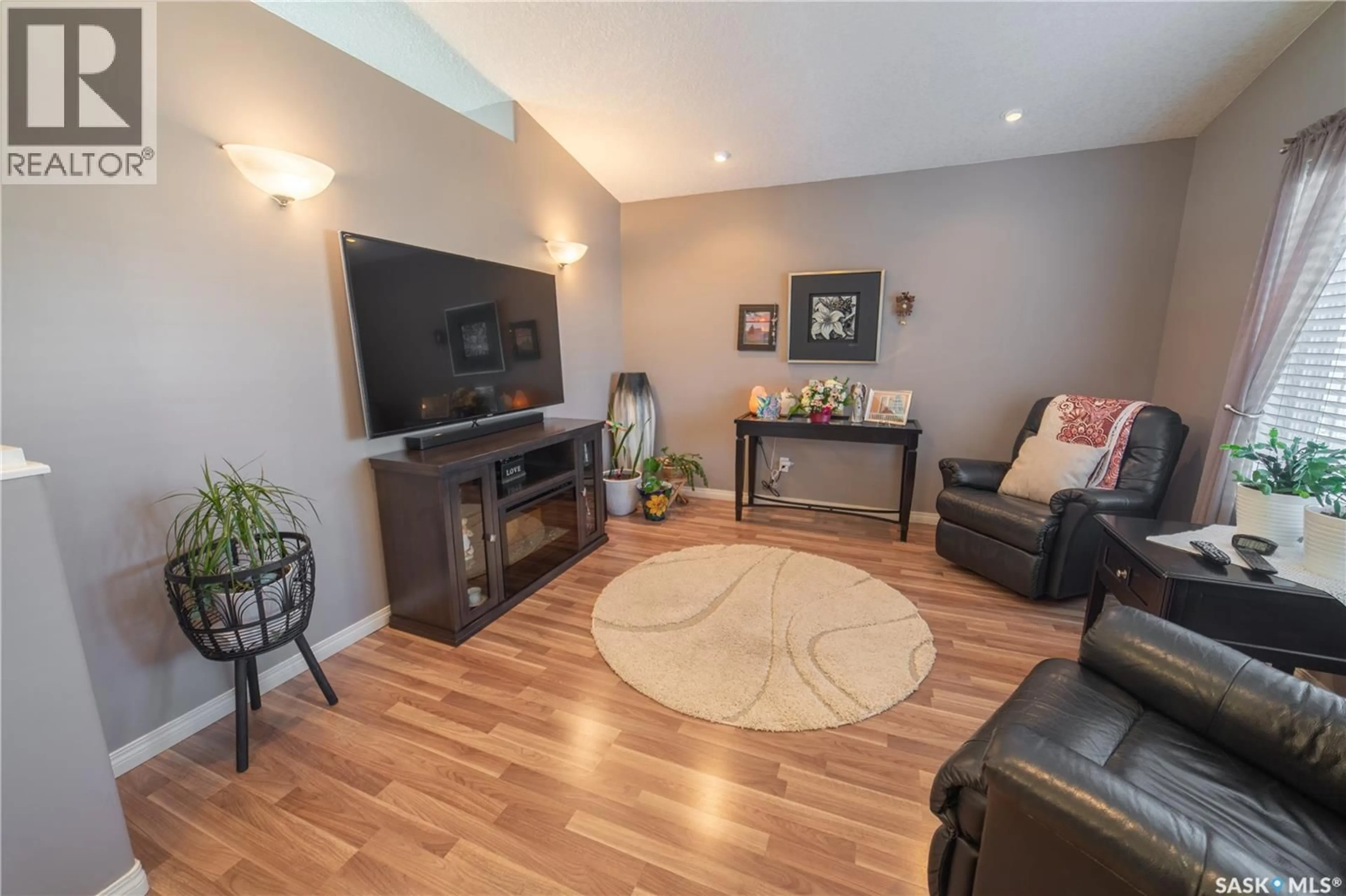 Living room with furniture, wood/laminate floor for 317 FREHLICK BAY, Estevan Saskatchewan S4A0Y1