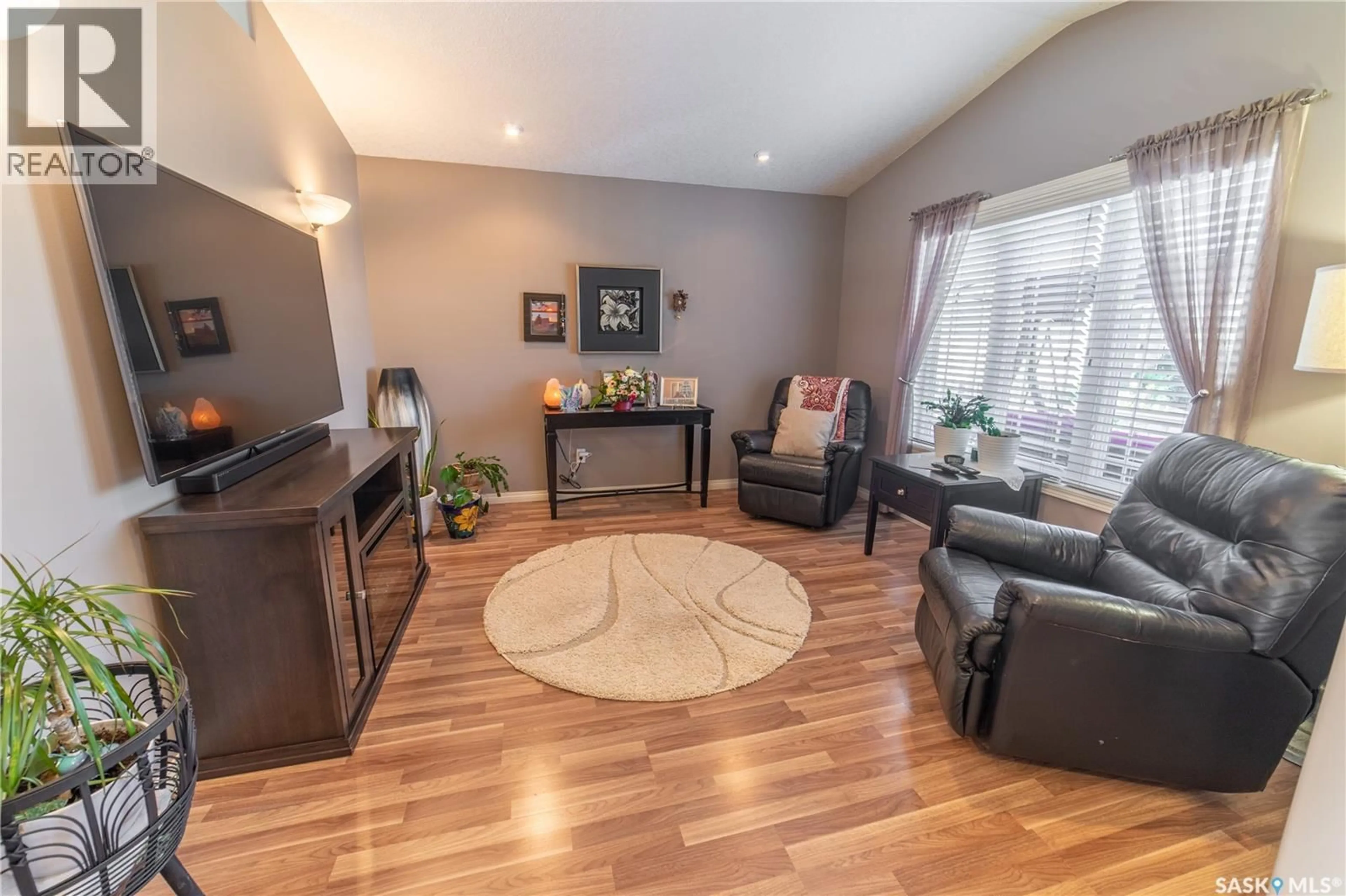 Living room with furniture, wood/laminate floor for 317 FREHLICK BAY, Estevan Saskatchewan S4A0Y1