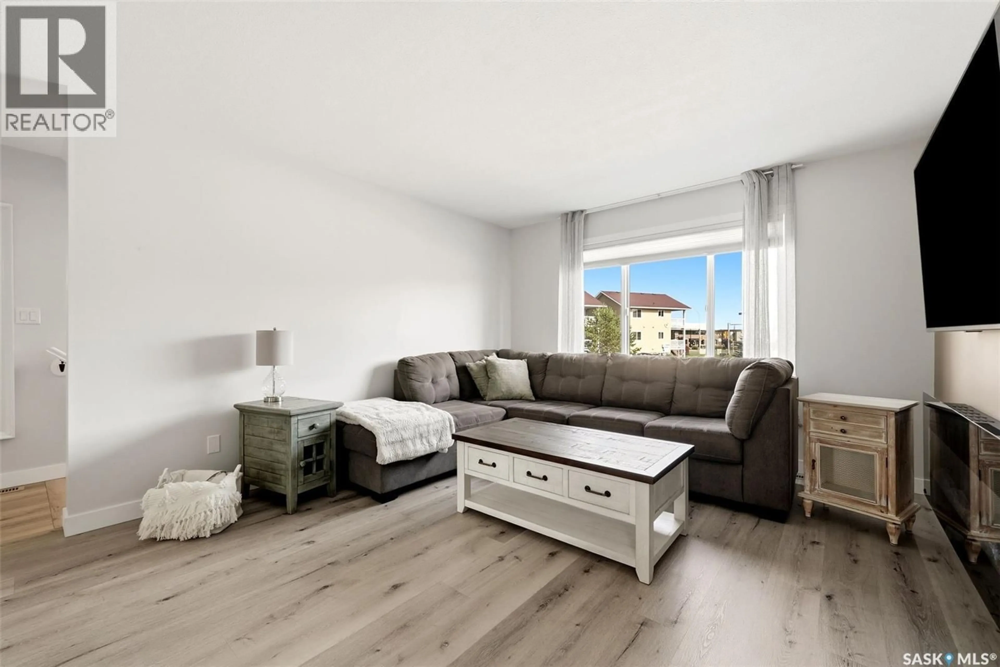 Living room with furniture, wood/laminate floor for 59 5004 JAMES HILL ROAD, Regina Saskatchewan S4W0E8
