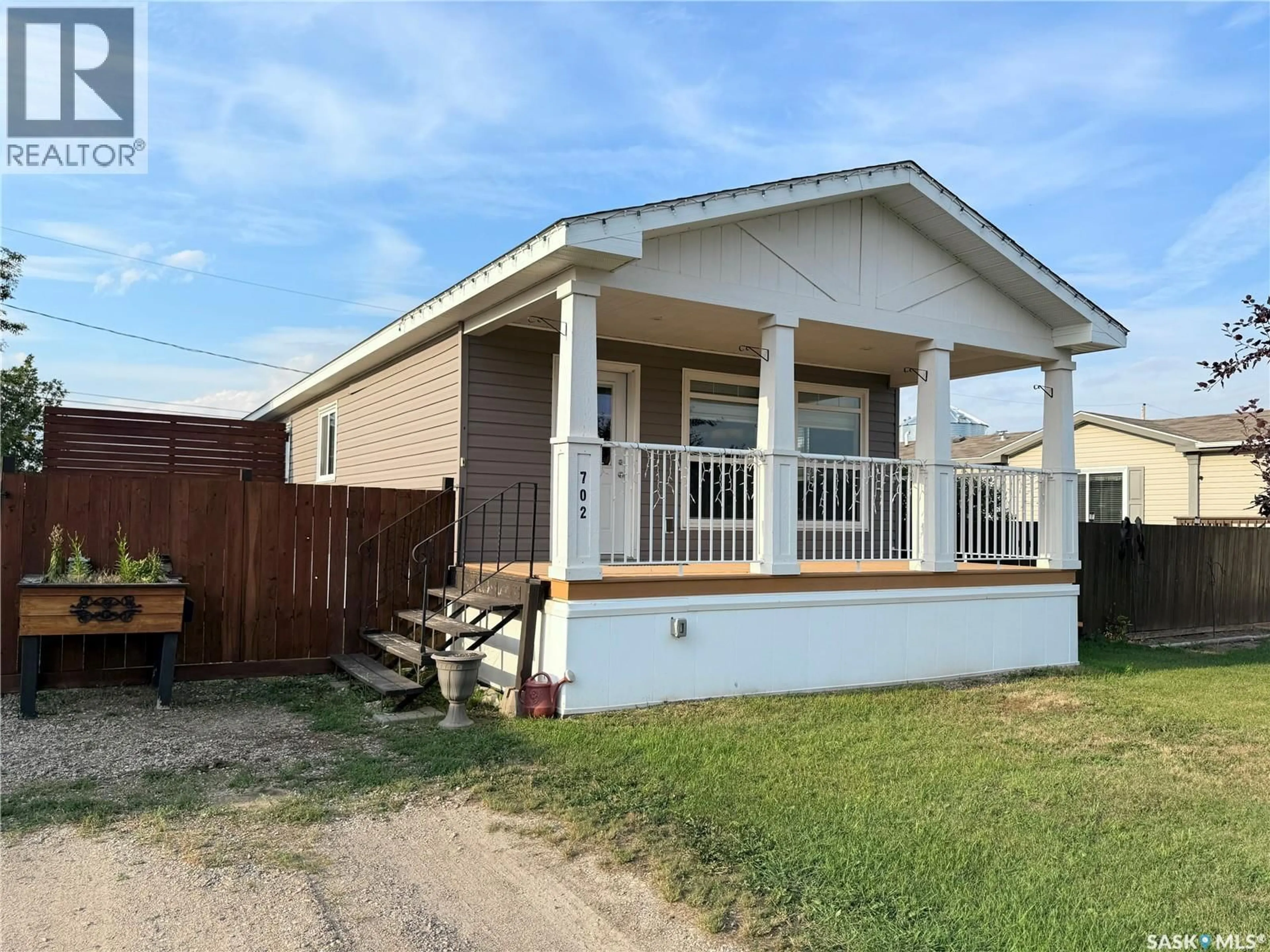Home with vinyl exterior material, street for 702 PRAIRIE AVENUE, Outlook Saskatchewan S0L2N0
