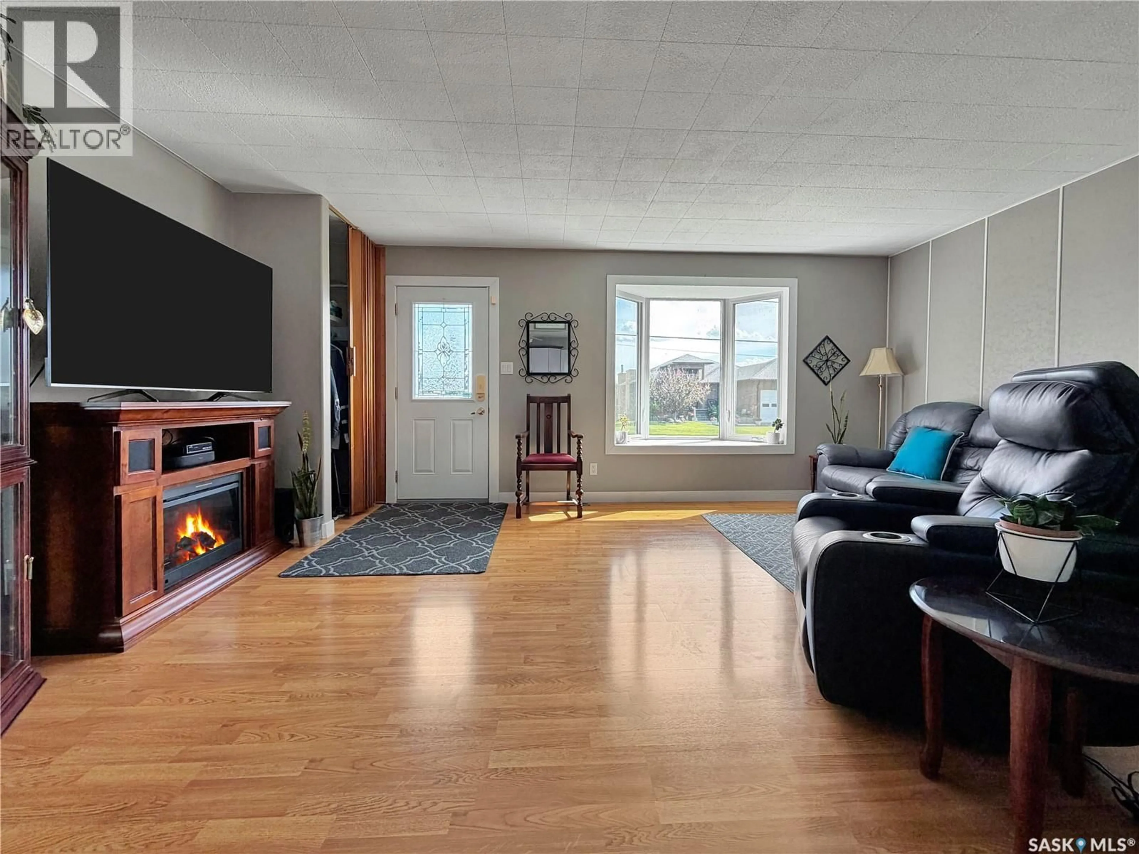 Living room with furniture, wood/laminate floor for 507 PRAIRIE AVENUE, Arcola Saskatchewan S0C0G0